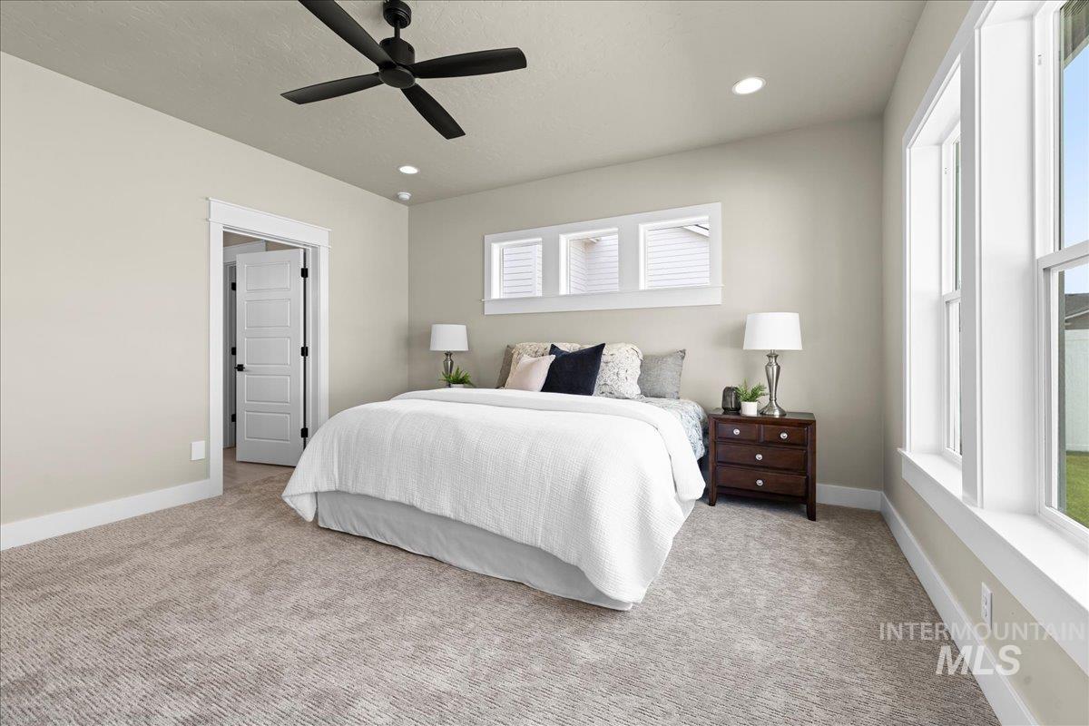 Bedroom with light carpet, ceiling fan, recessed lighting, and a textured ceiling