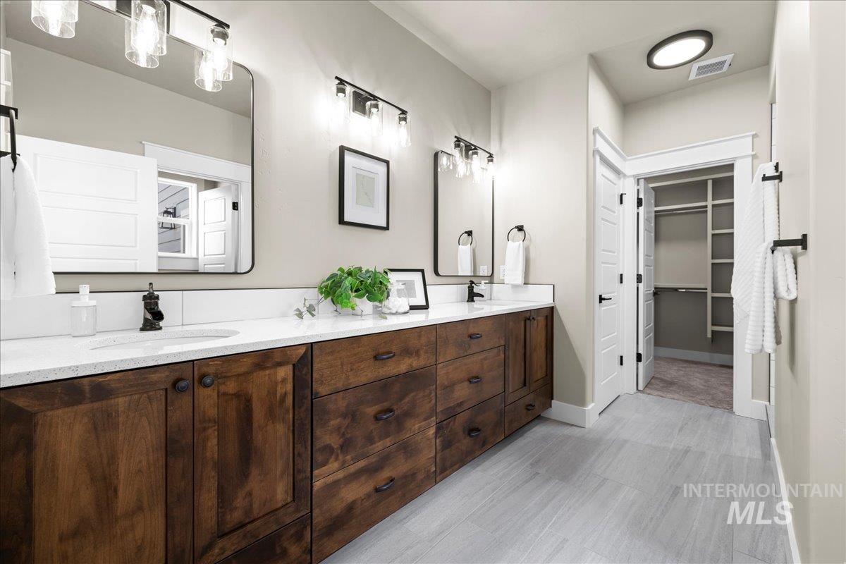 Bathroom with double vanity and a spacious closet