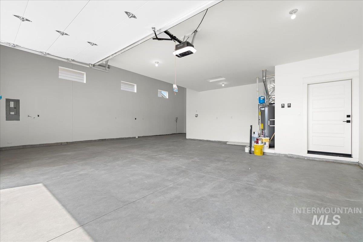 Garage featuring electric panel and a garage door opener