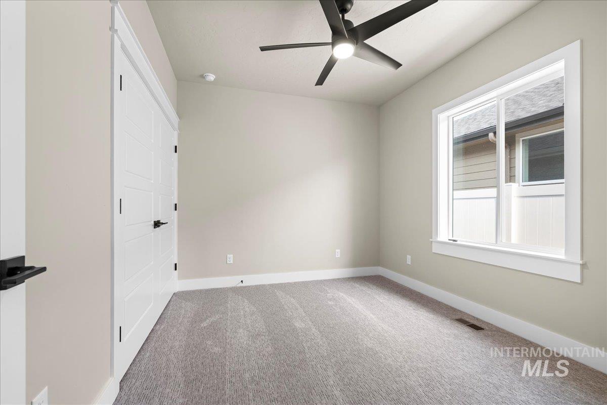 Unfurnished bedroom featuring carpet and a ceiling fan