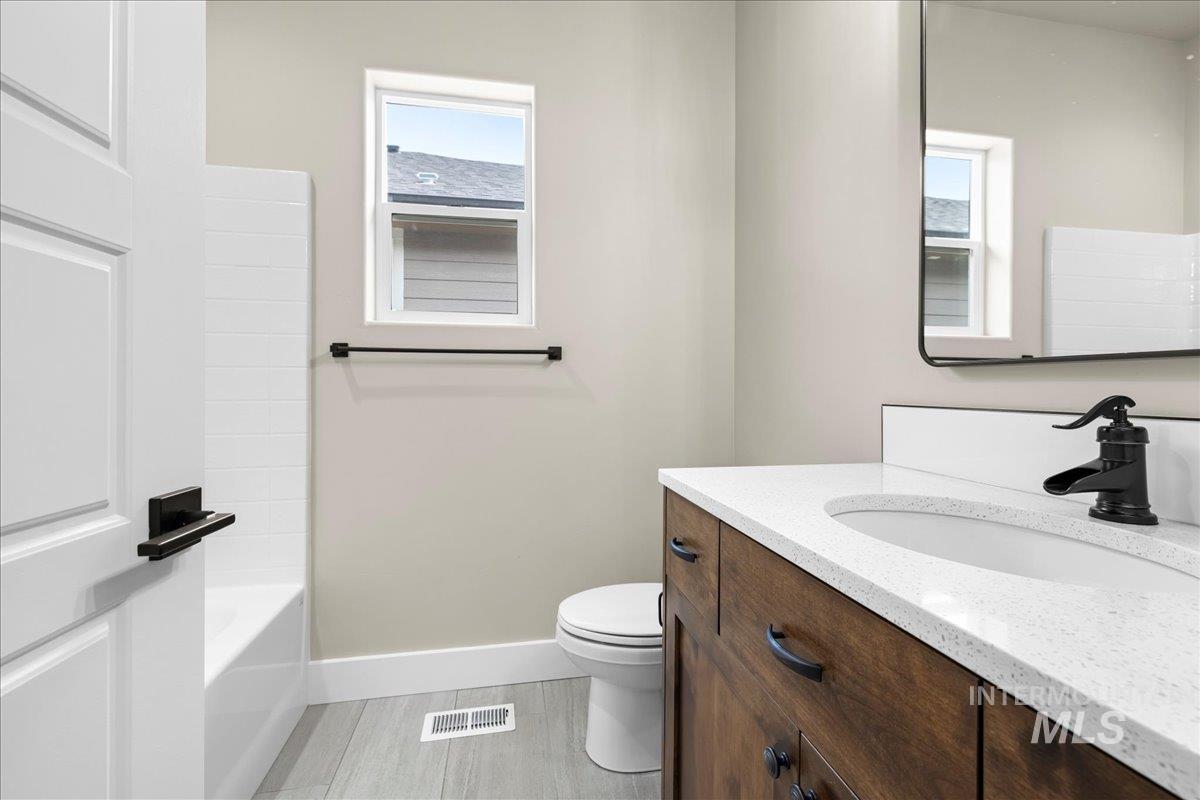 Bathroom with vanity, healthy amount of natural light, and bathtub / shower combination
