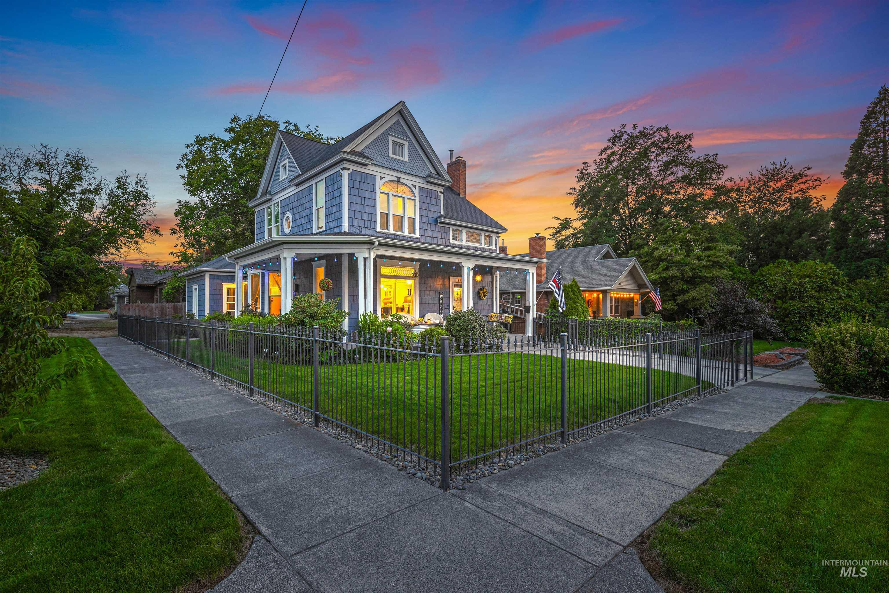 View of front of property with a porch, a chimney, and a fenced front yard