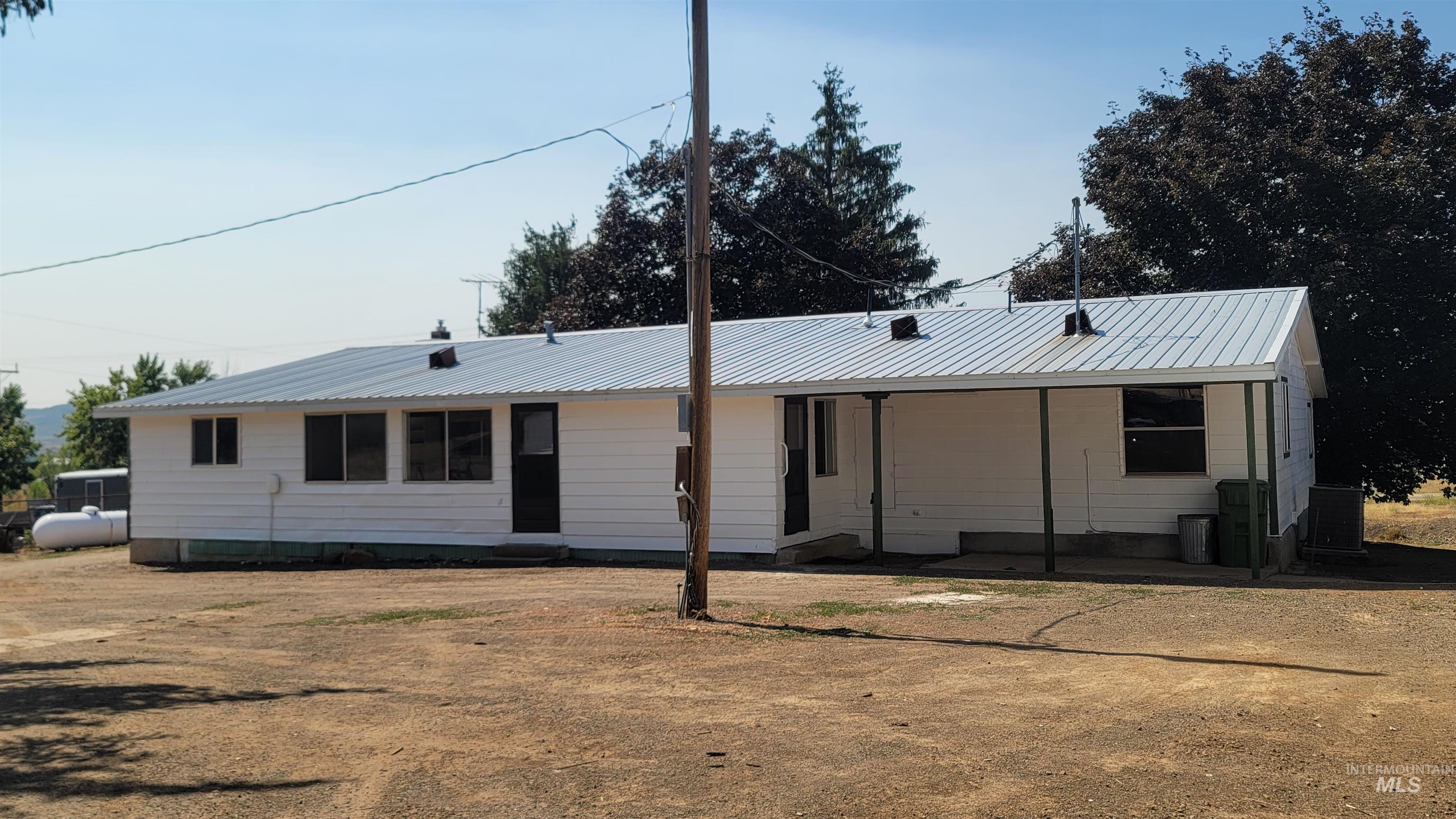 View of front of home featuring a metal roof and crawl space