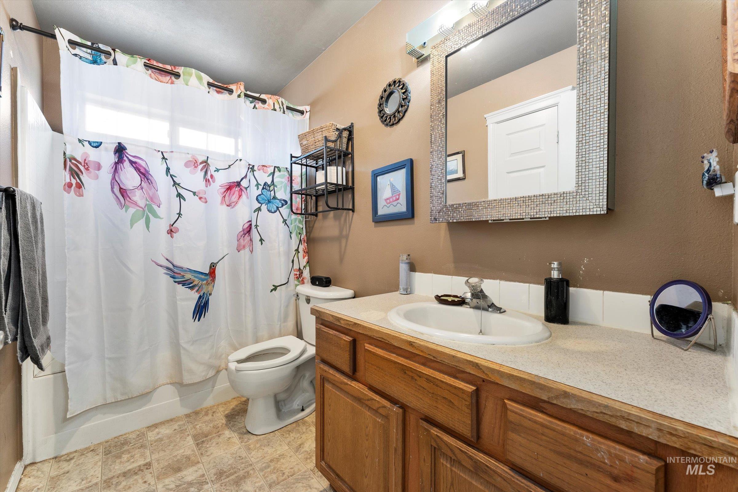 Full bath with shower / bath combo with shower curtain and vanity