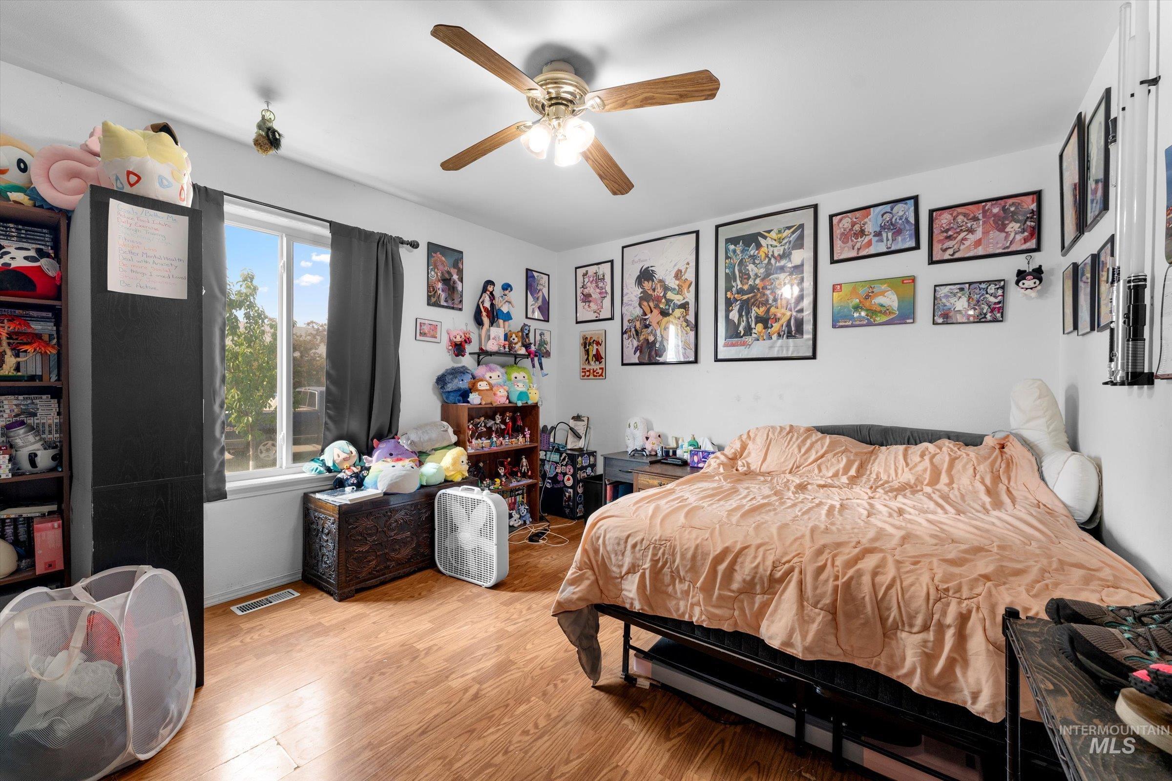 Bedroom with wood finished floors and a ceiling fan