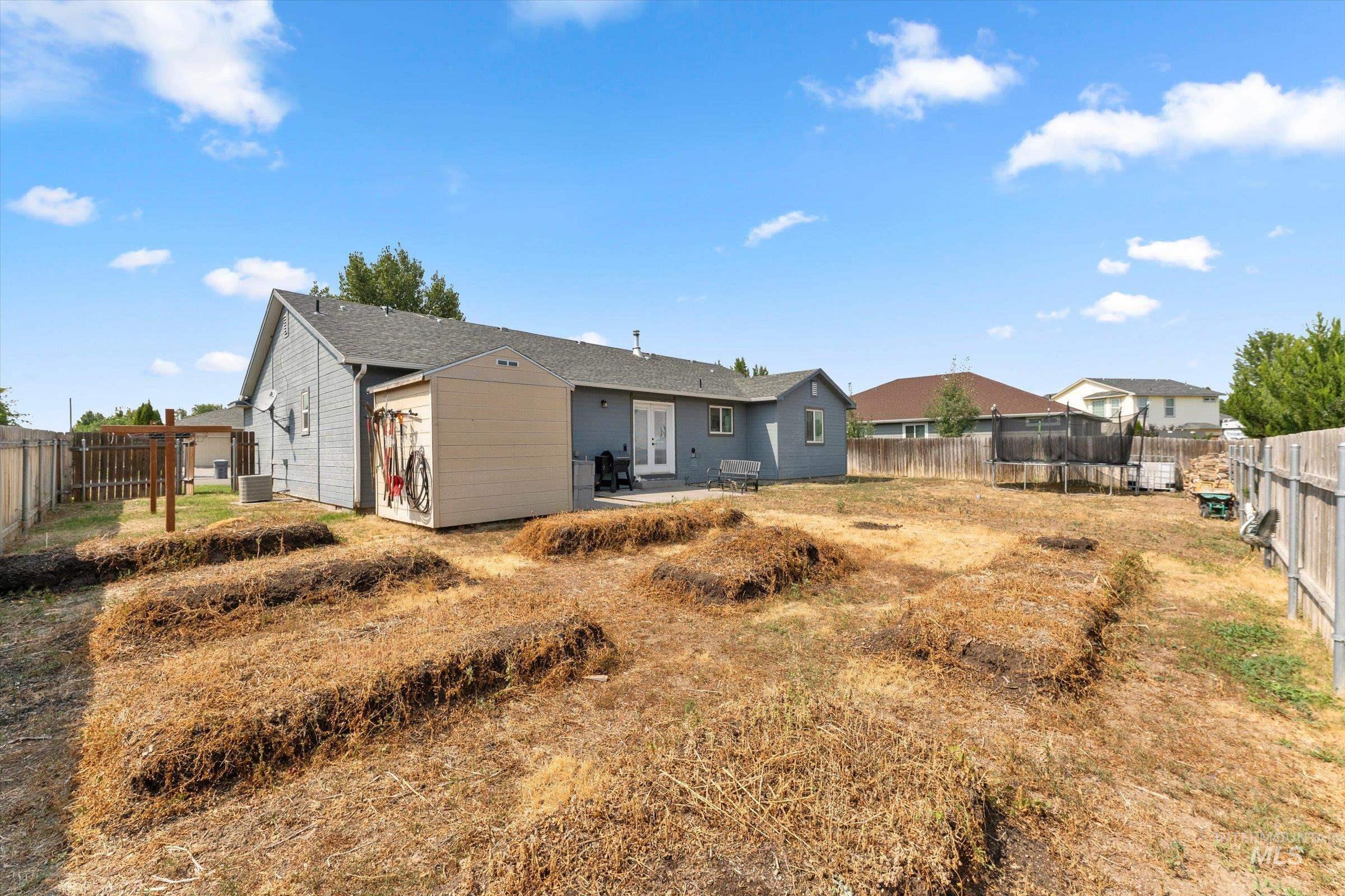 Rear view of property with a patio, a fenced backyard, and a trampoline