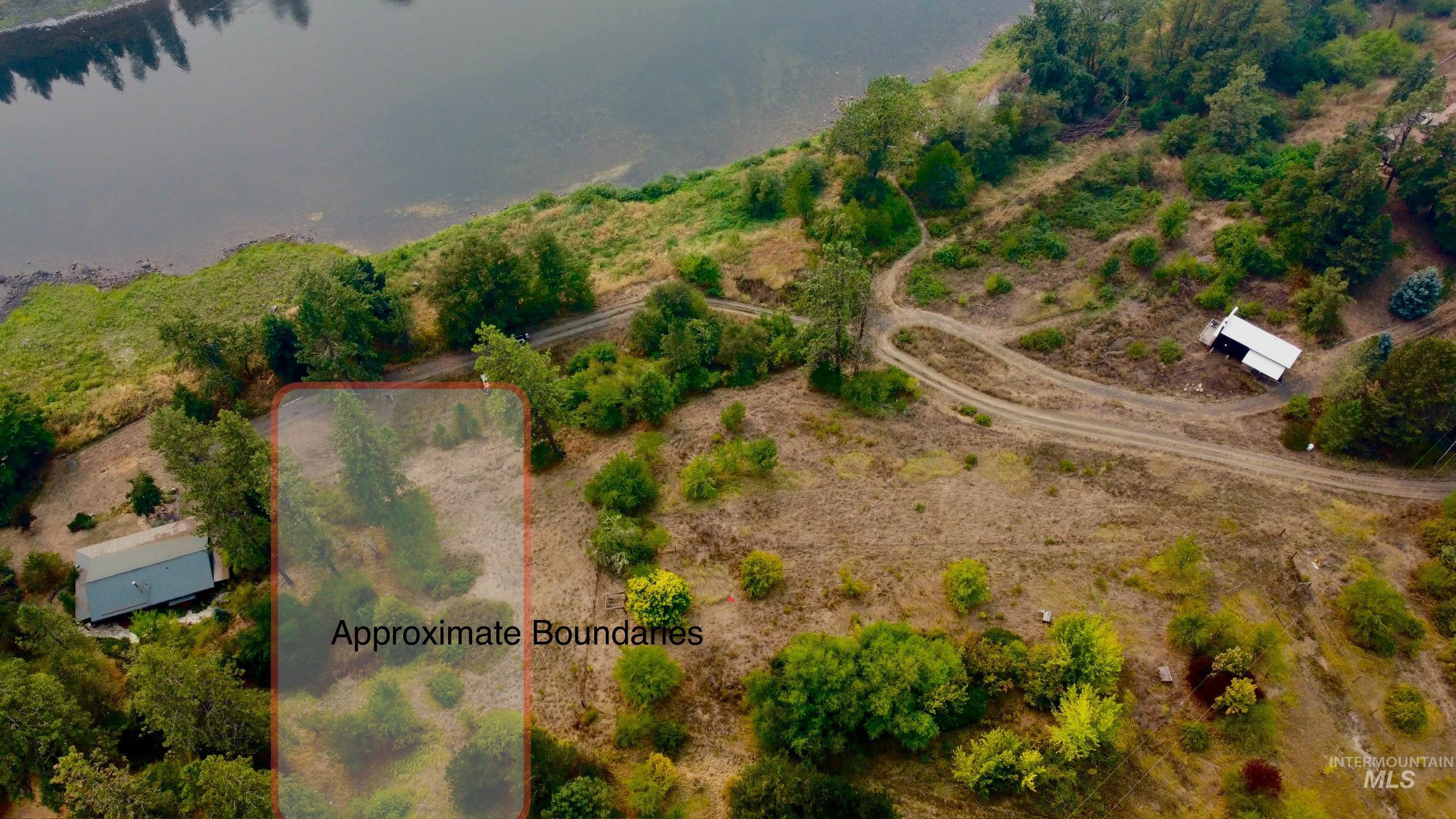 Aerial view of property and surrounding area featuring property parcel outlined and a nearby body of water