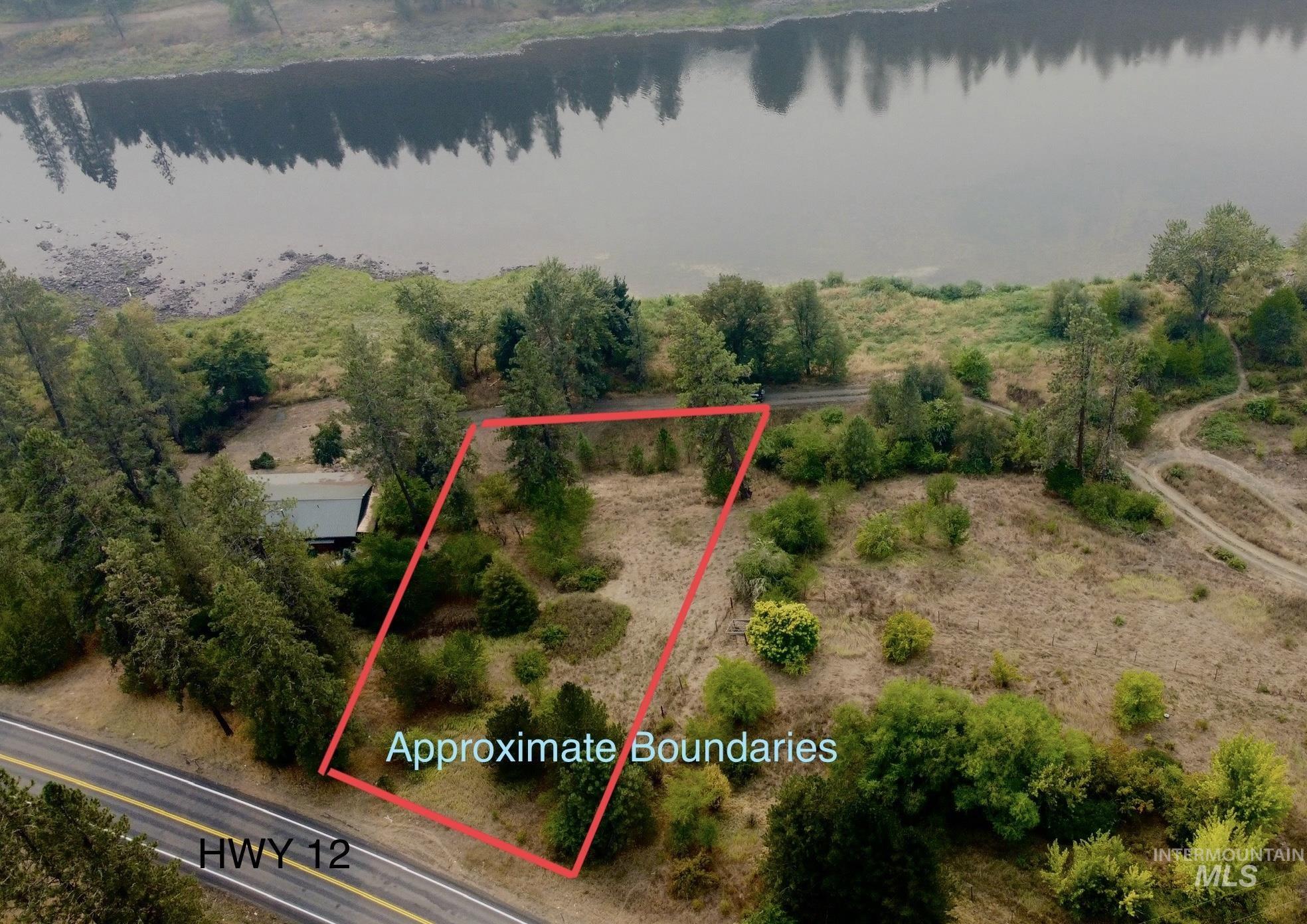 Aerial view of property and surrounding area with a large body of water and property parcel outlined