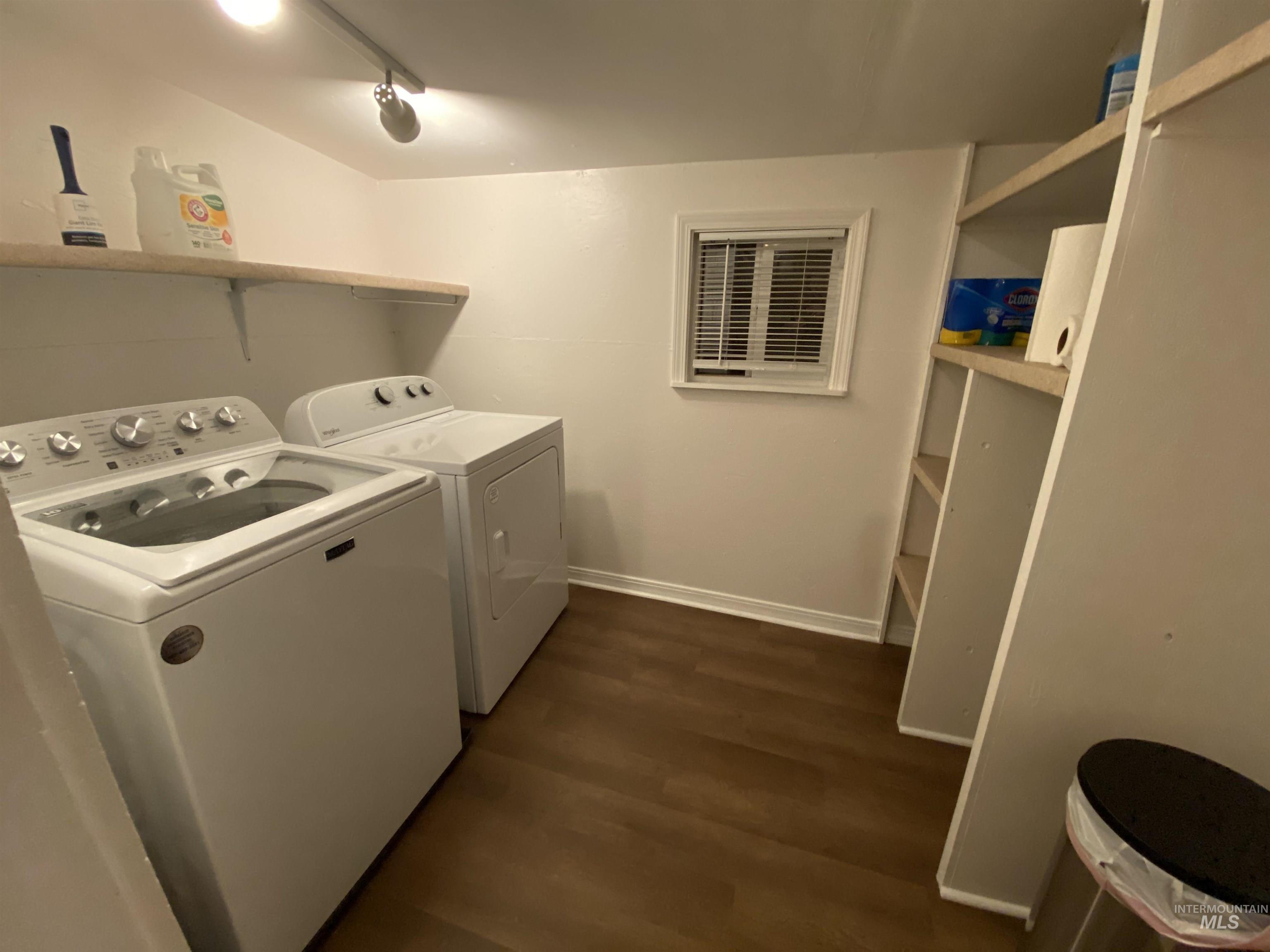 Washroom with dark wood finished floors and washing machine and dryer