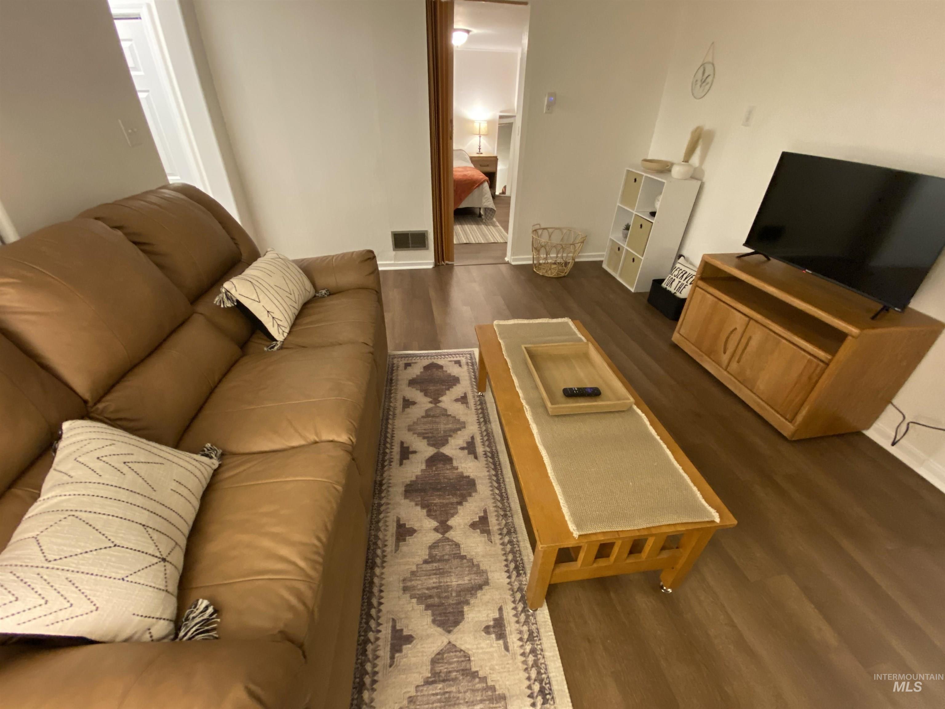 Living area featuring dark wood-style flooring