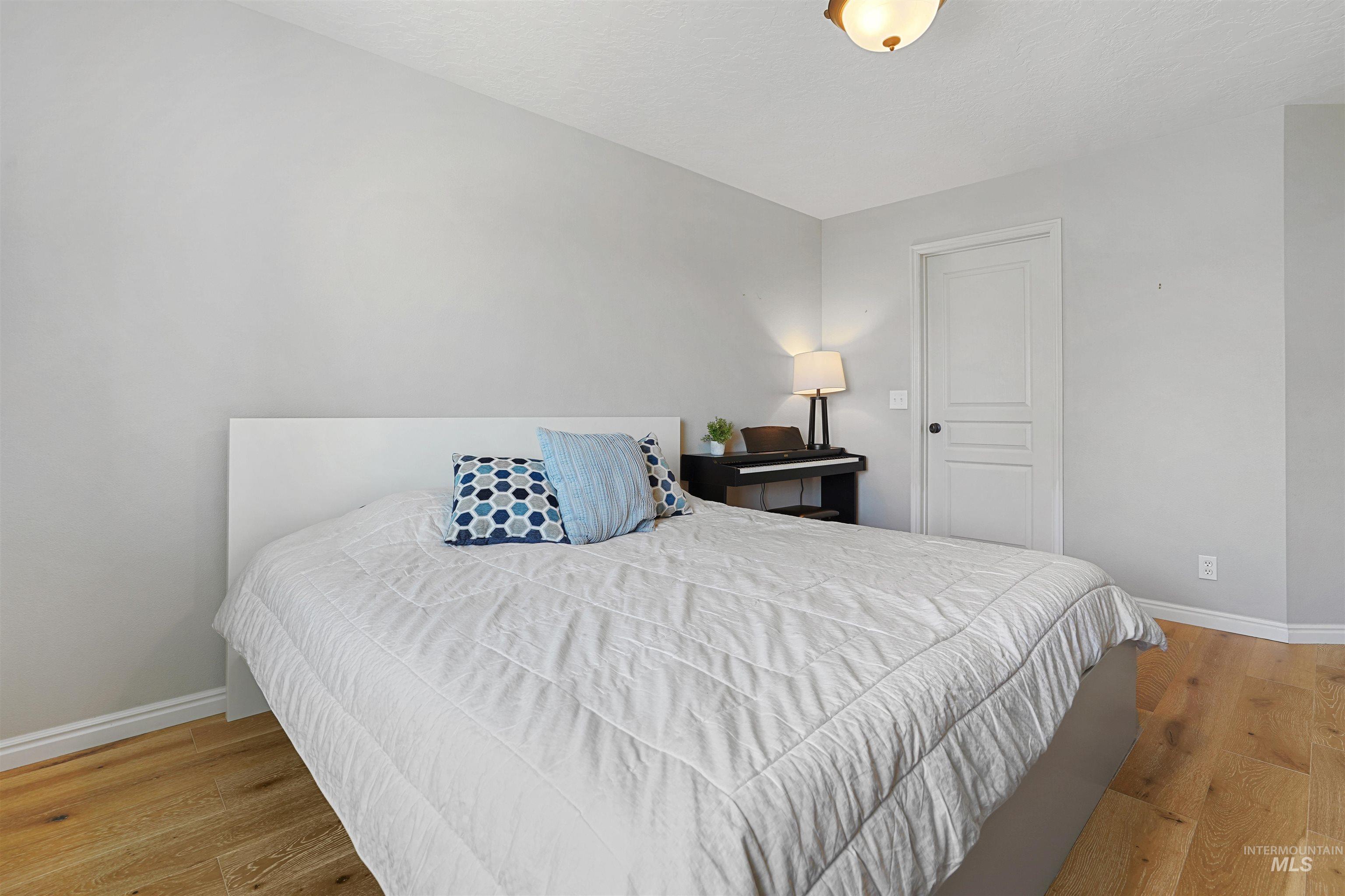 Bedroom with light wood-type flooring and a textured ceiling