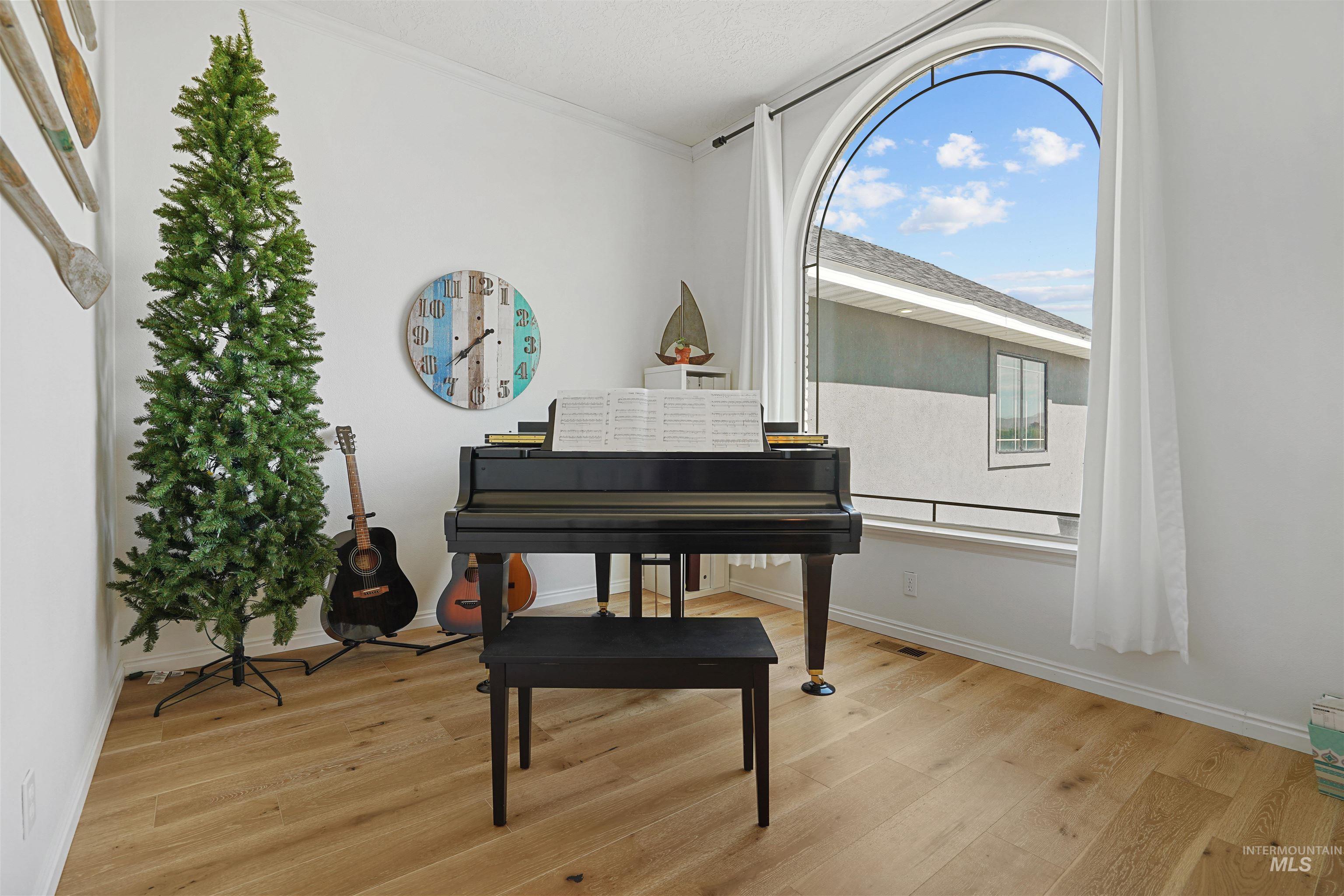 Sitting room featuring light wood finished floors and ornamental molding