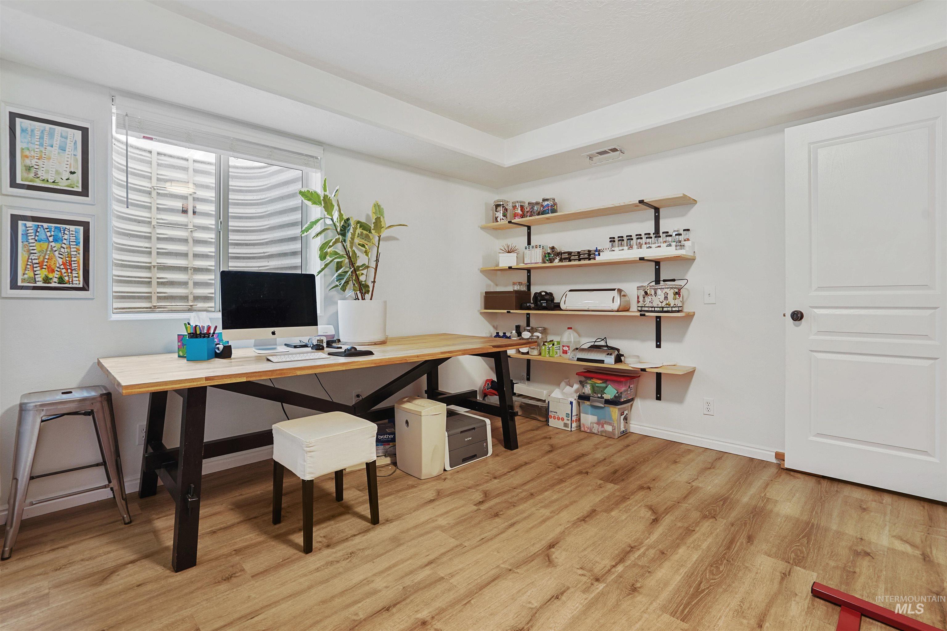 Home office with light wood finished floors and baseboards