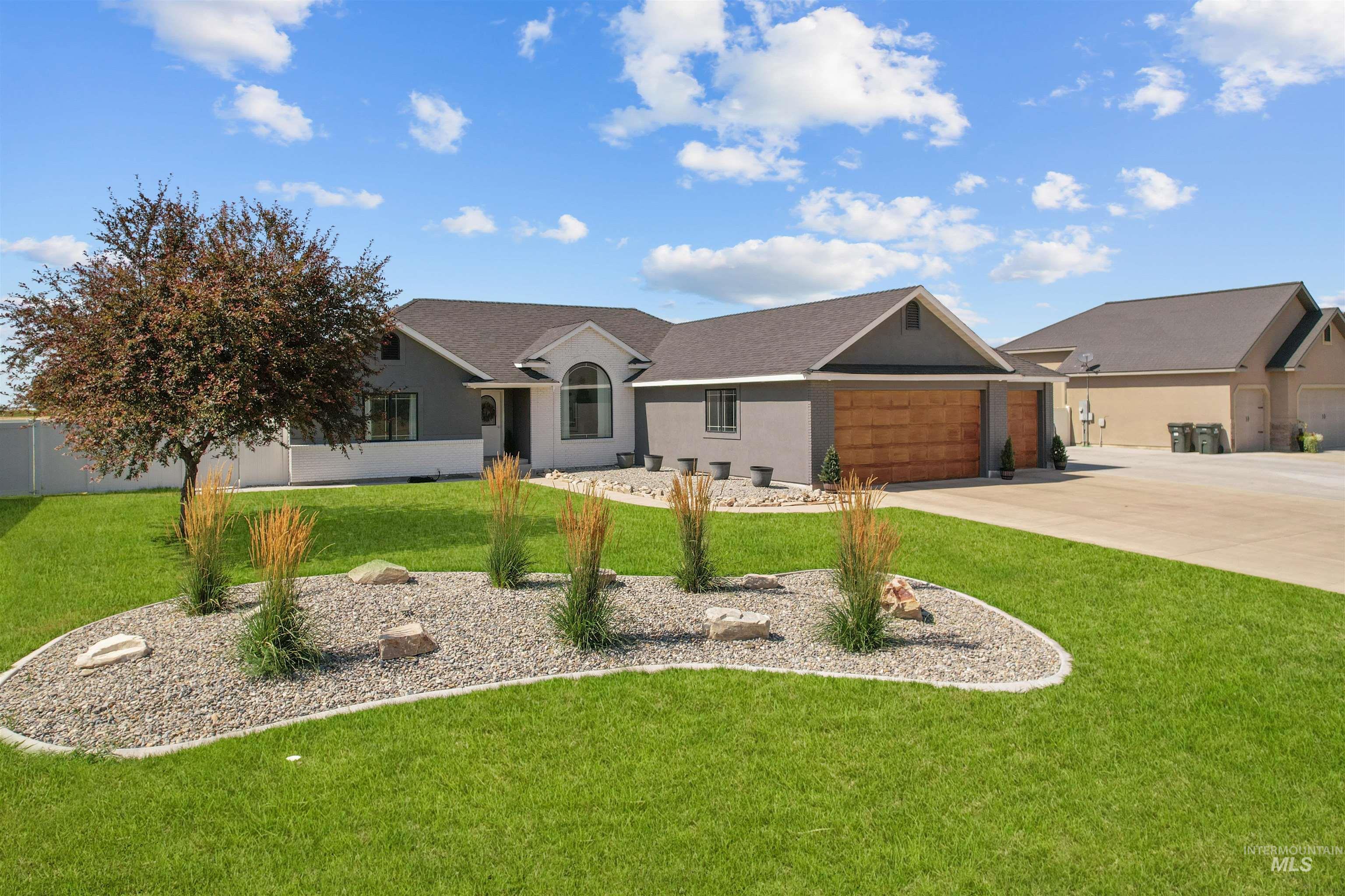 Ranch-style house with stucco siding, a front lawn, driveway, a garage, and roof with shingles