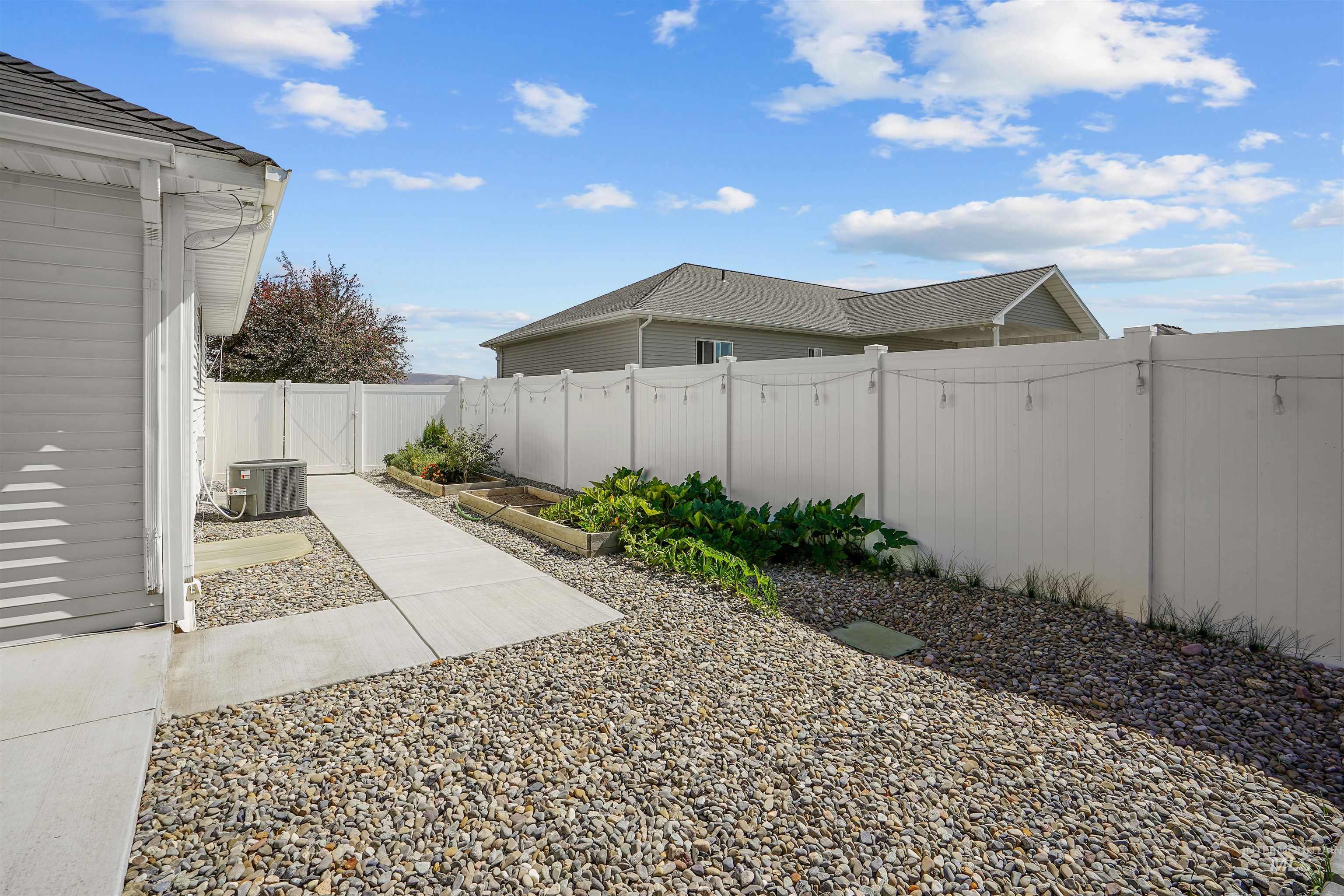 Fenced backyard featuring a vegetable garden