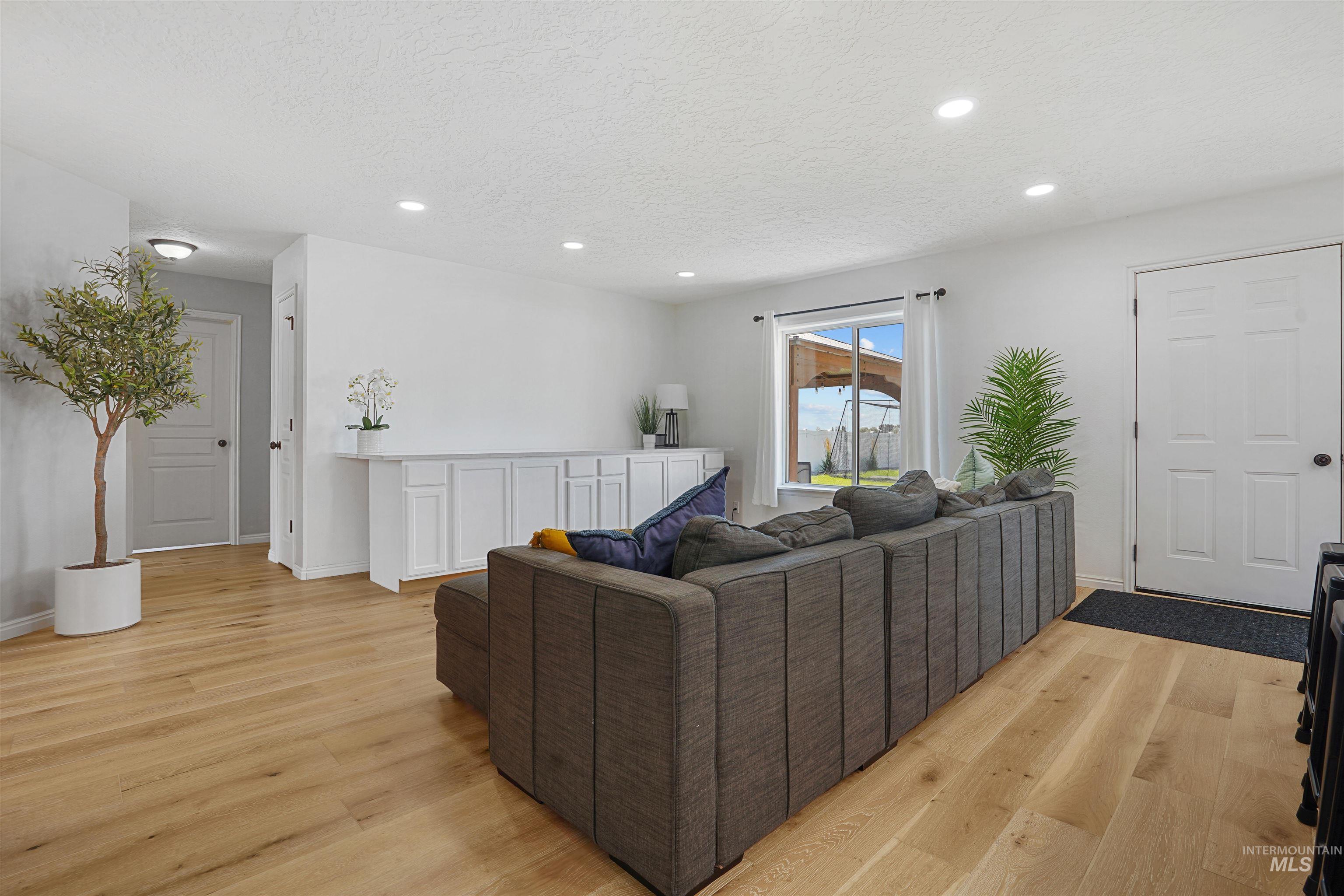 Living area featuring recessed lighting, light wood-type flooring, and a textured ceiling