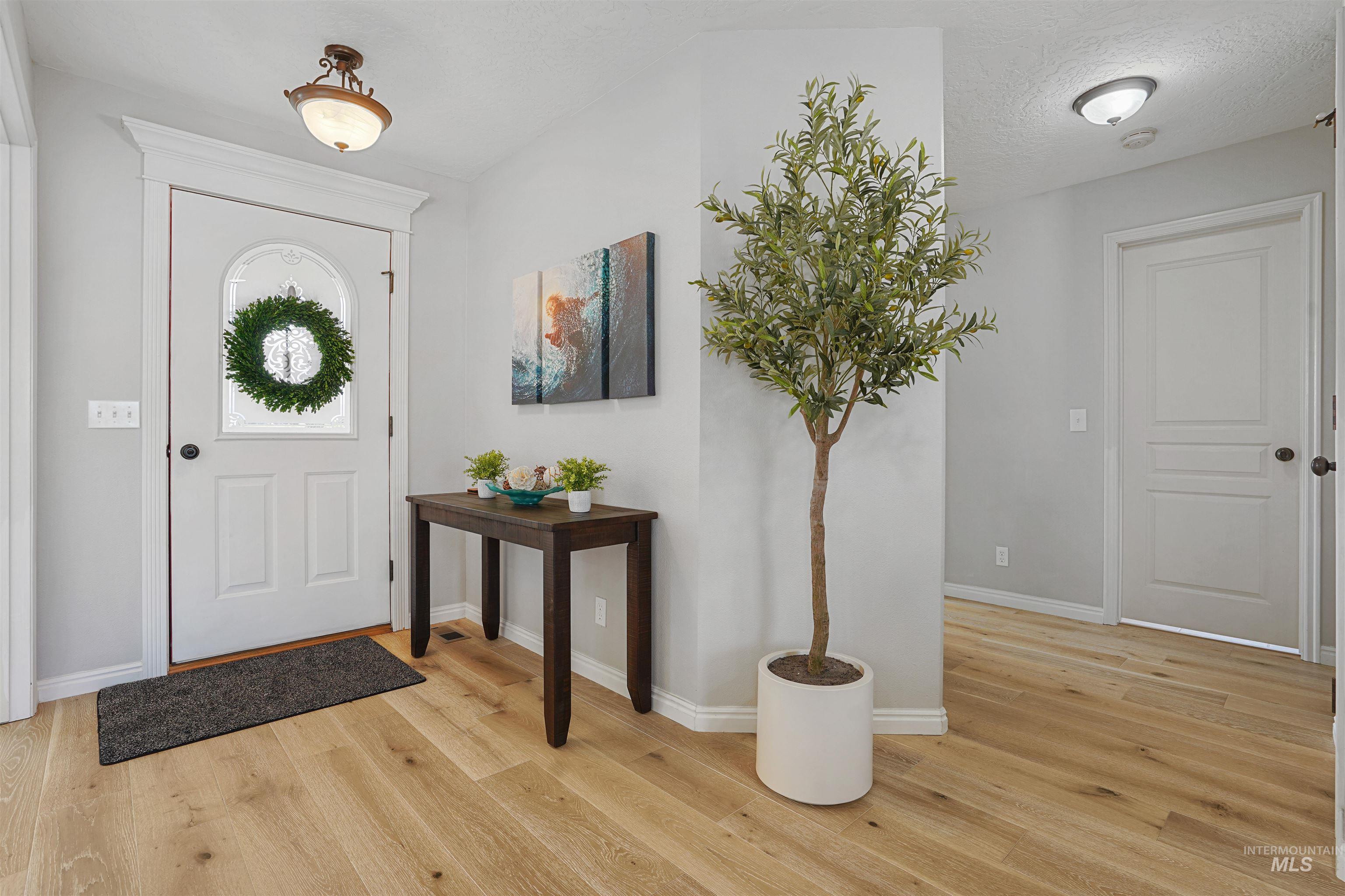 Entrance foyer featuring light wood finished floors and a textured ceiling