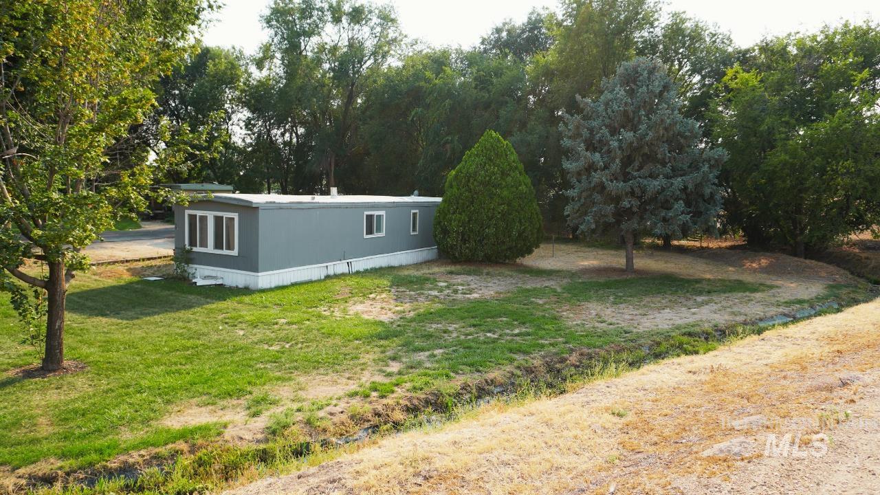 View of green lawn featuring view of scattered trees