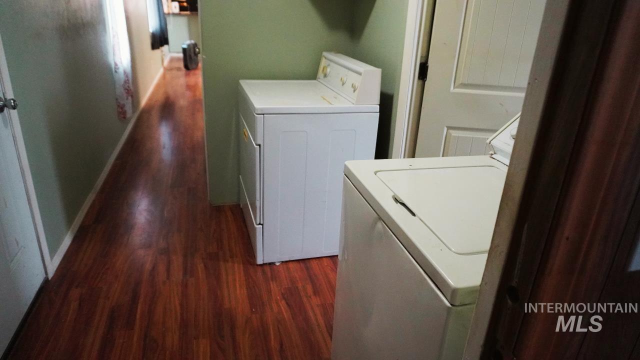 Washroom featuring dark wood-style flooring and washing machine and clothes dryer