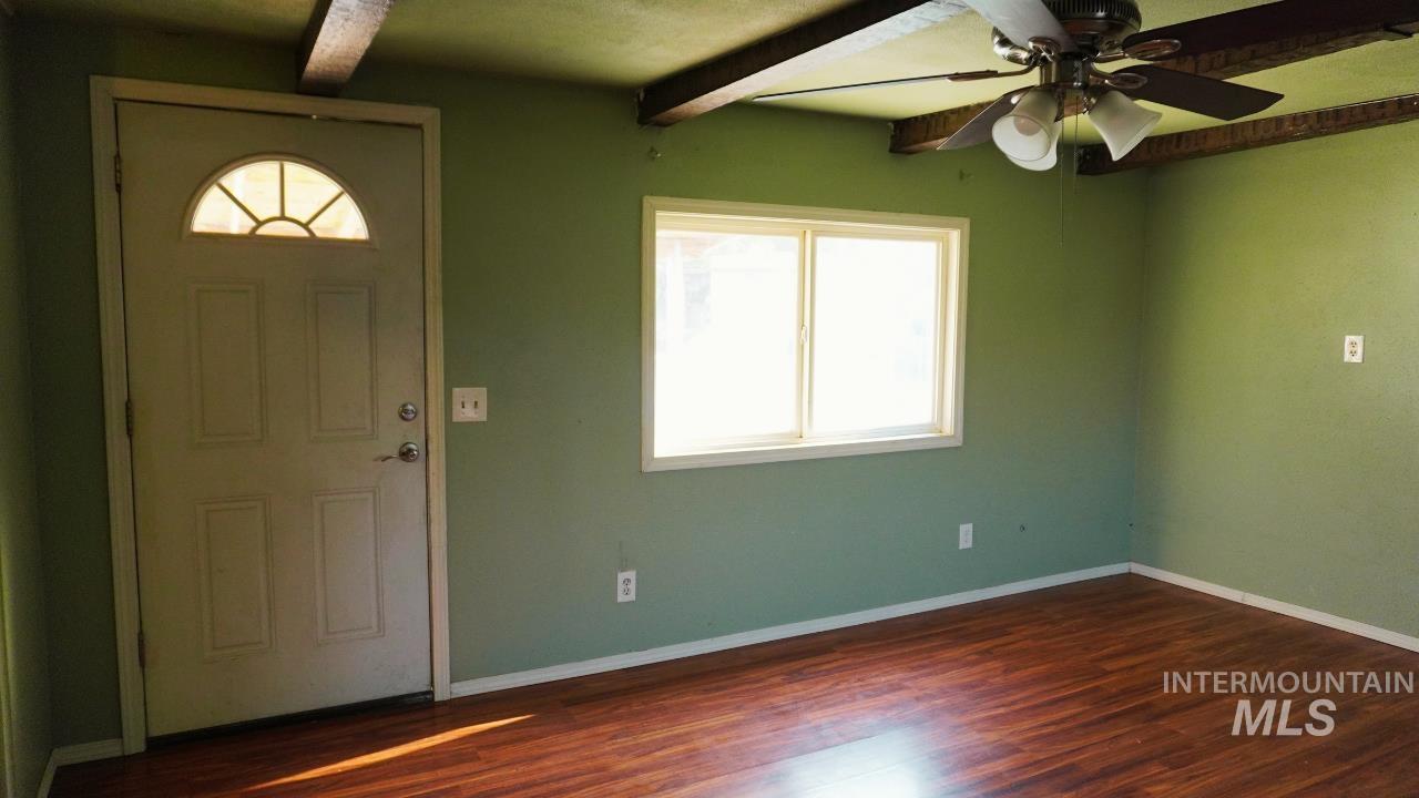 Foyer entrance featuring a ceiling fan, dark wood-type flooring, and beamed ceiling