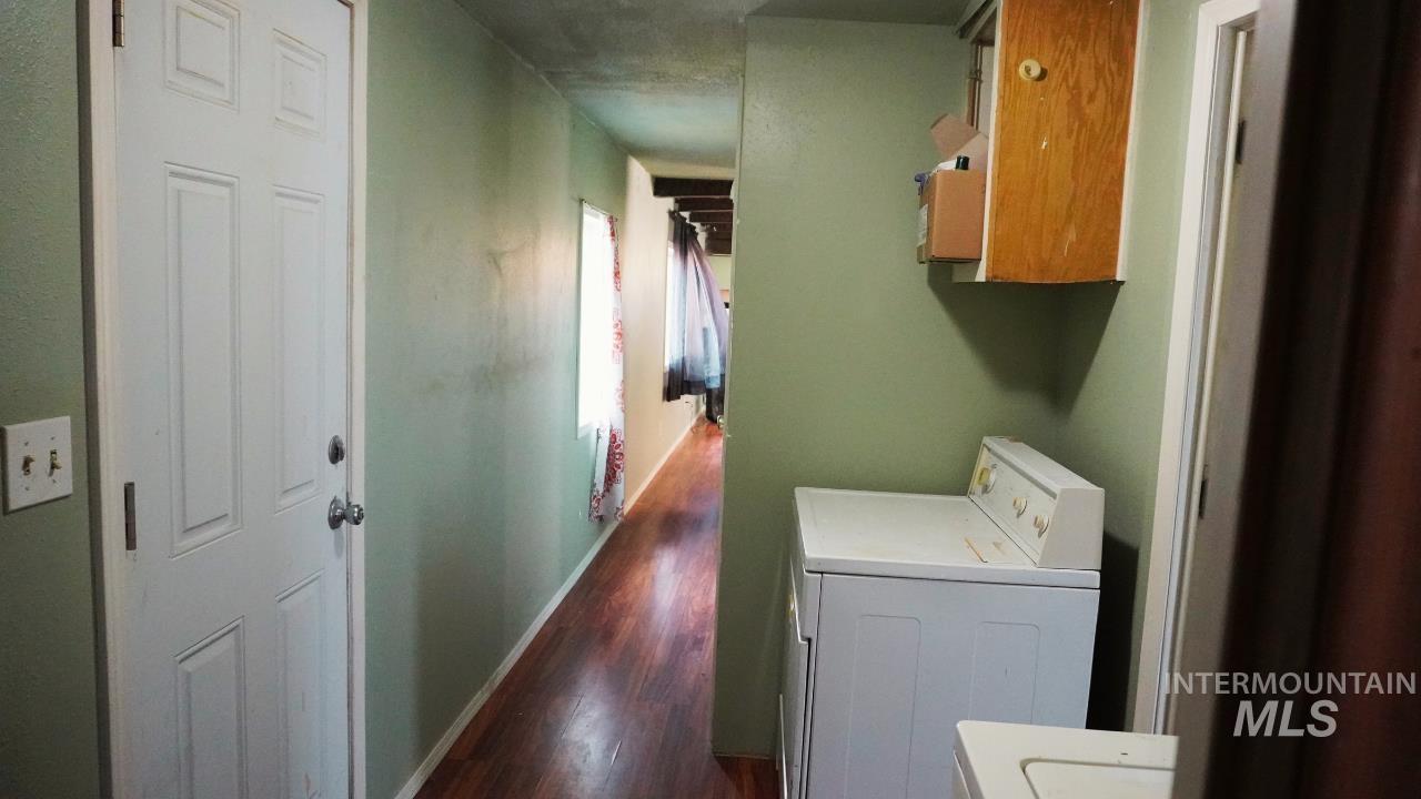 Laundry area with washer / dryer, dark wood finished floors, and cabinet space