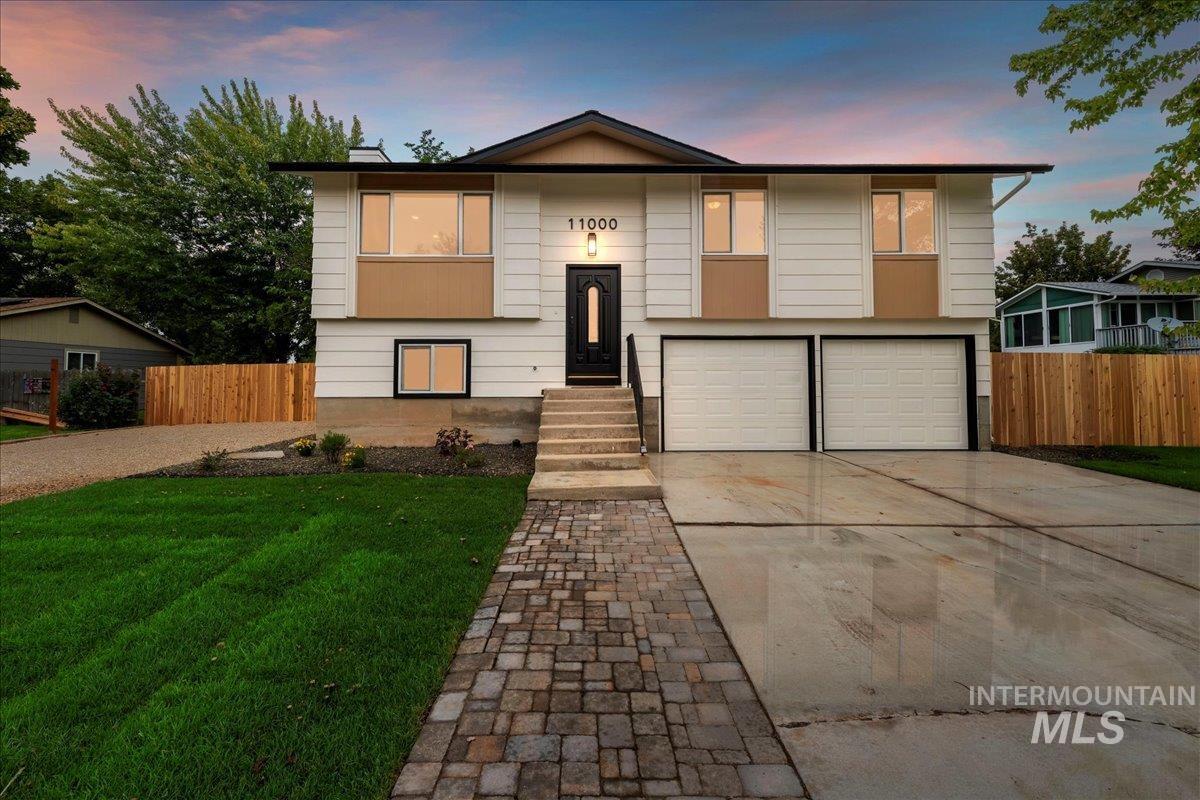 Raised ranch with concrete driveway and a garage