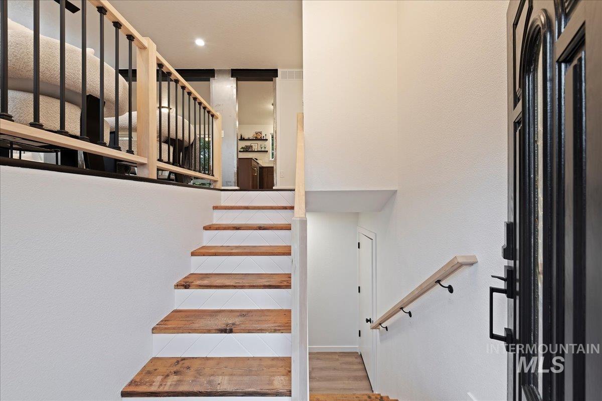 Stairway featuring wood finished floors