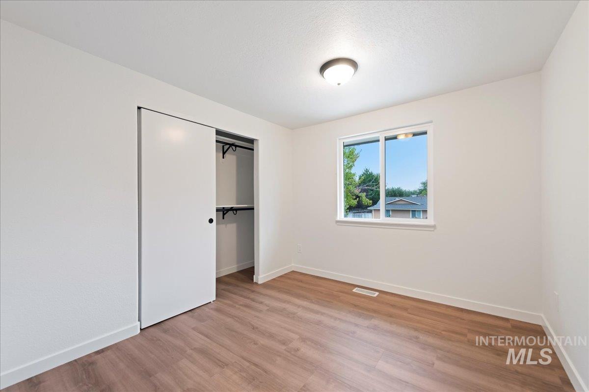 Unfurnished bedroom with light wood finished floors and a closet