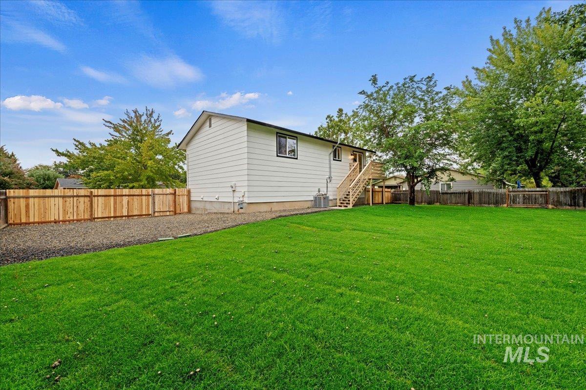 Back of house with a fenced backyard and stairway
