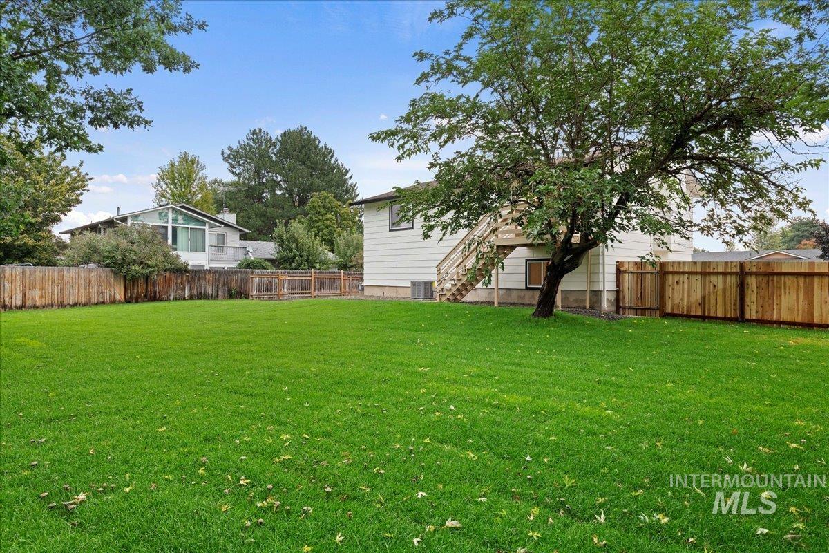 Fenced backyard featuring stairs