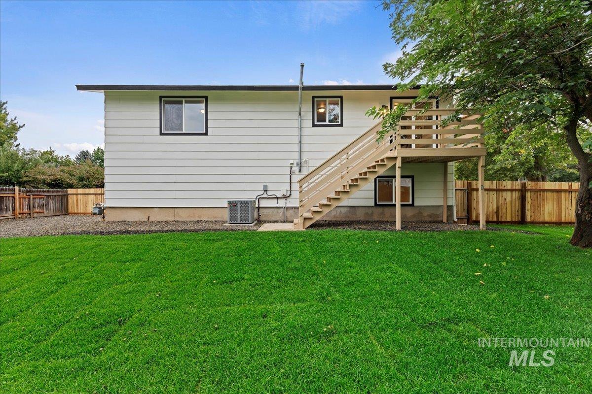 Rear view of property with stairs and a fenced backyard