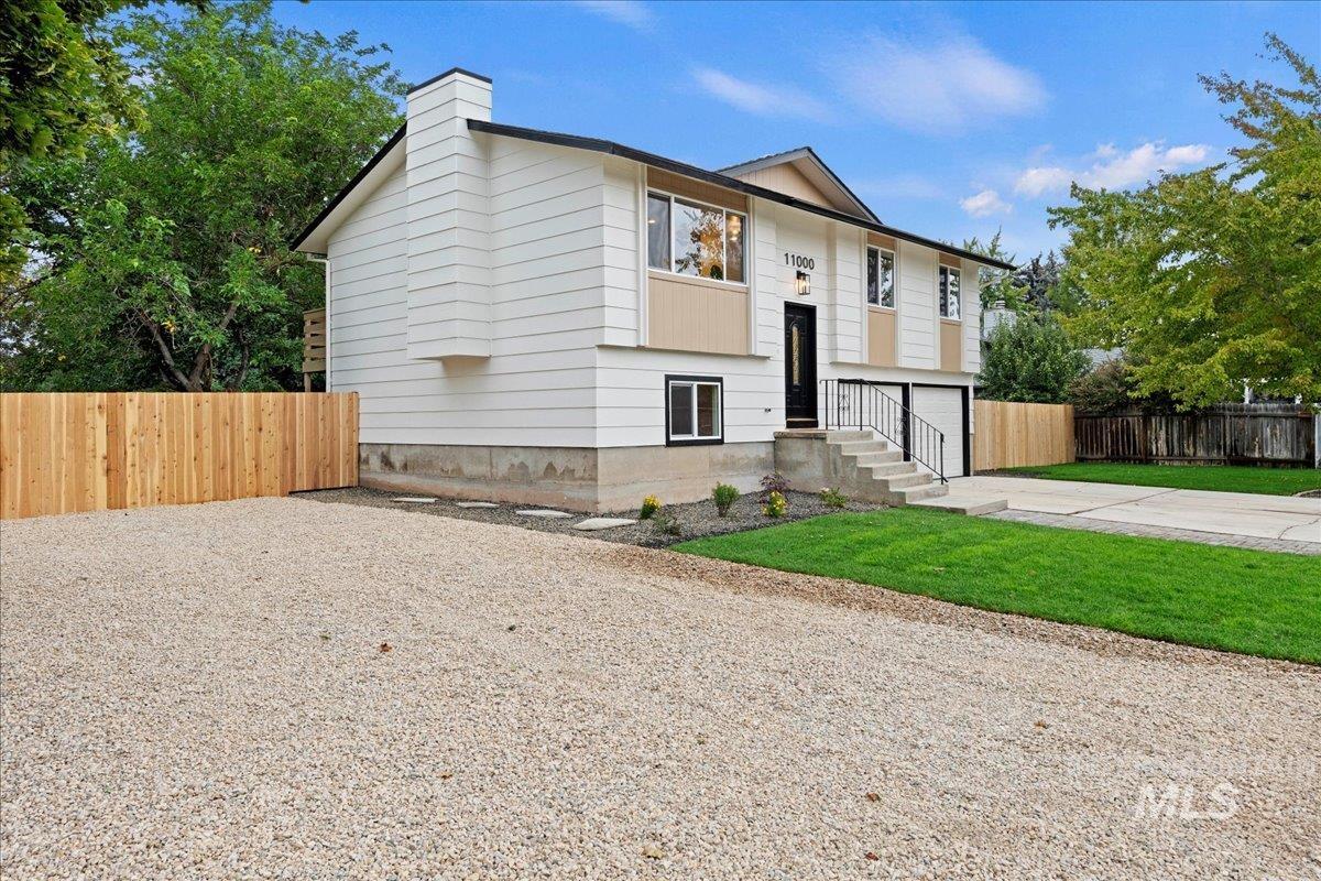 View of front of property with driveway, a garage, and a chimney