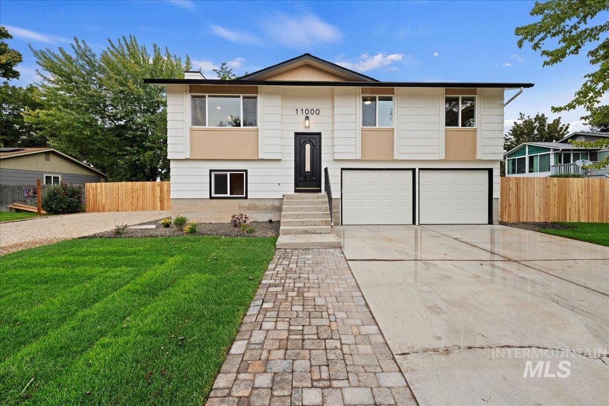 Bi-level home with concrete driveway and an attached garage