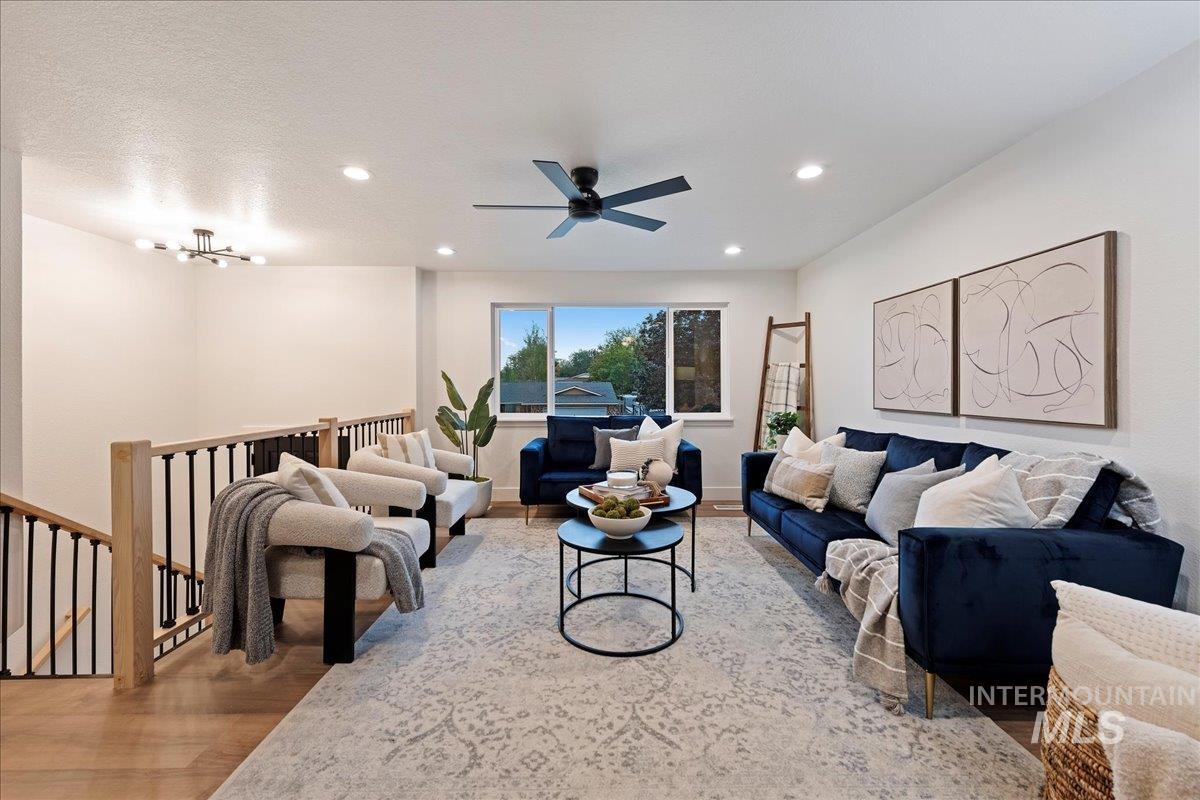 Living room with light wood-type flooring, recessed lighting, and ceiling fan