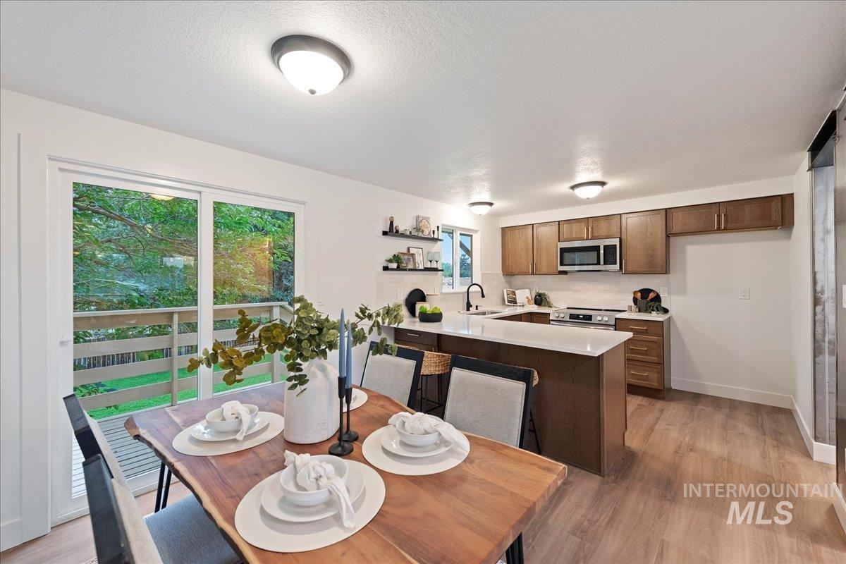 Dining area featuring light wood-style flooring and a textured ceiling