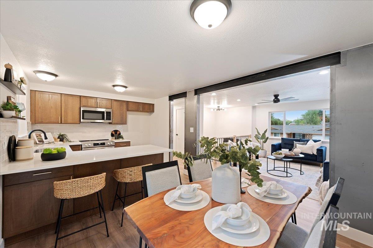 Dining area featuring light wood-style floors, ceiling fan, and a textured ceiling