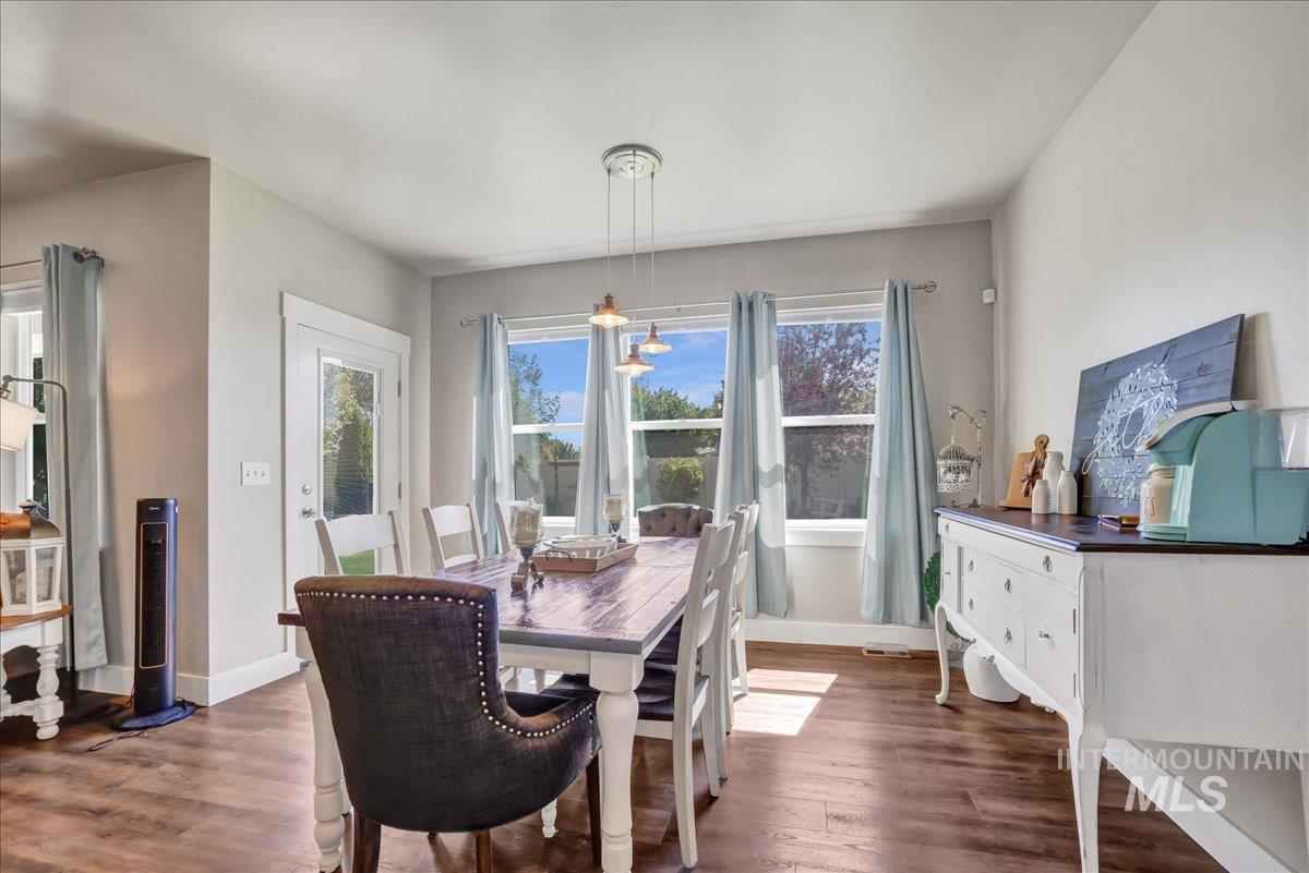 Dining area featuring dark wood-style floors and plenty of natural light