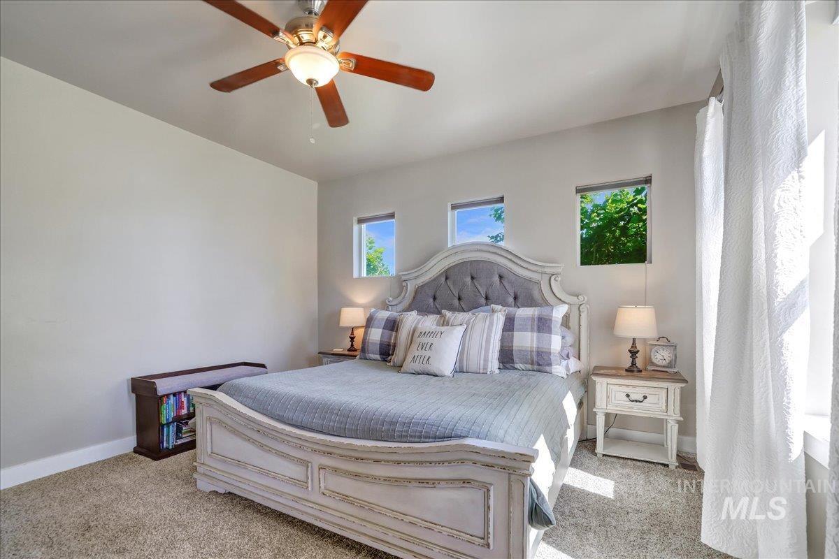 Bedroom featuring light colored carpet and ceiling fan