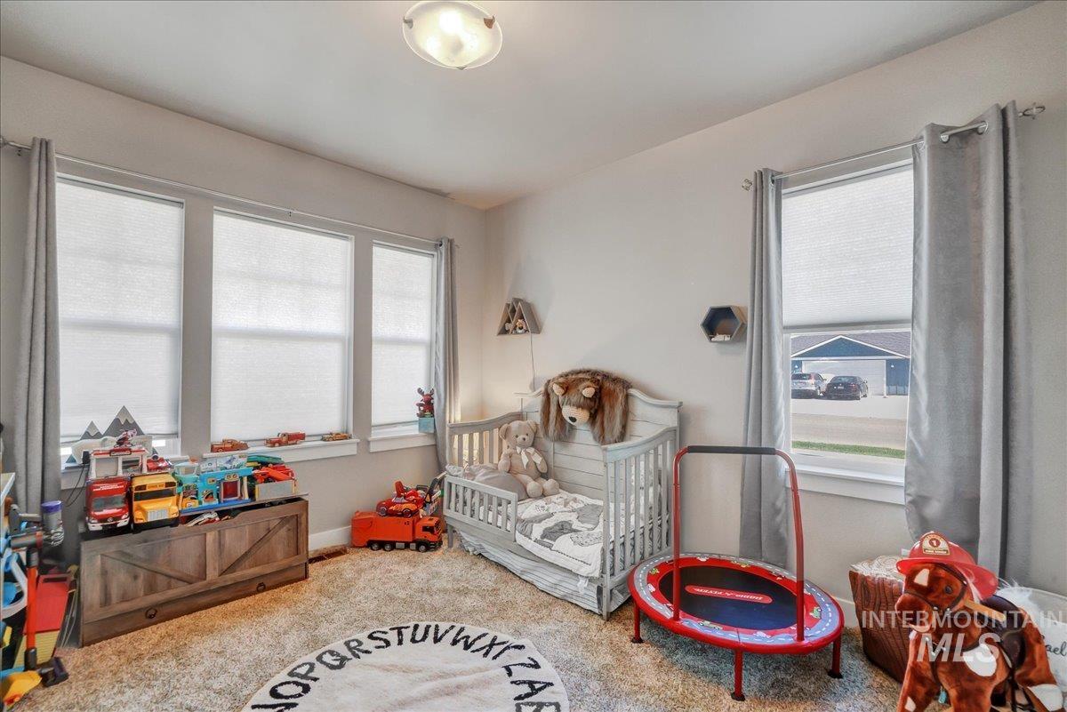 Bedroom featuring a crib and carpet