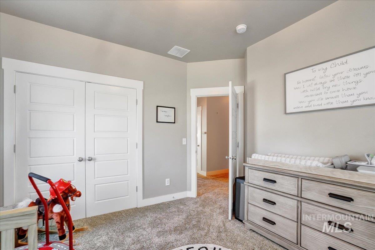 Bedroom featuring light carpet and a closet