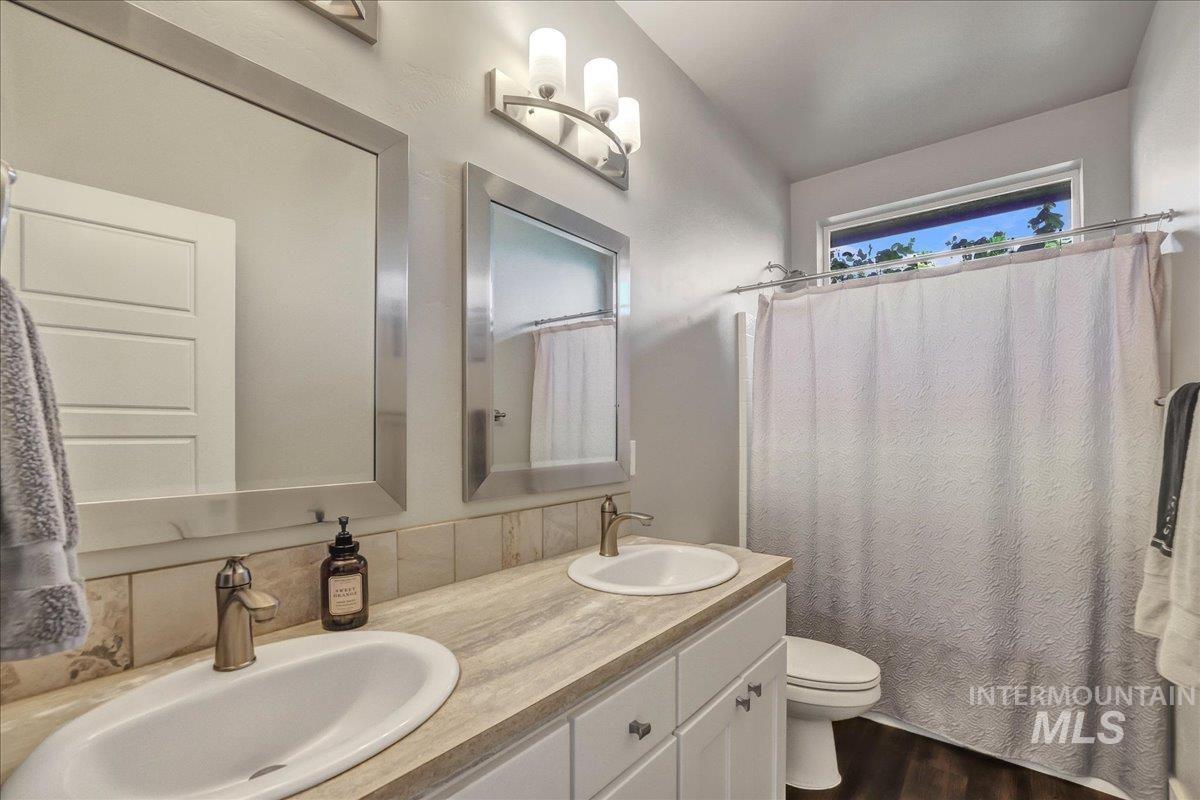Bathroom with double vanity and wood finished floors