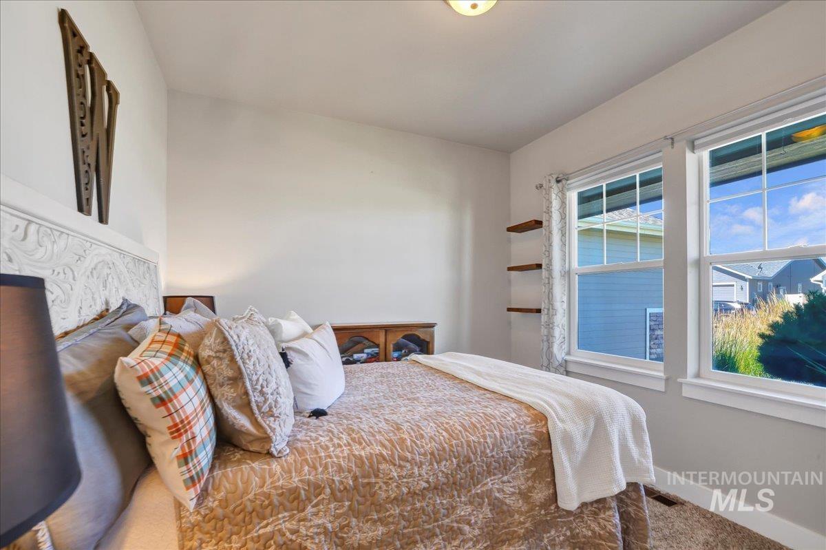 Bedroom with multiple windows and carpet flooring