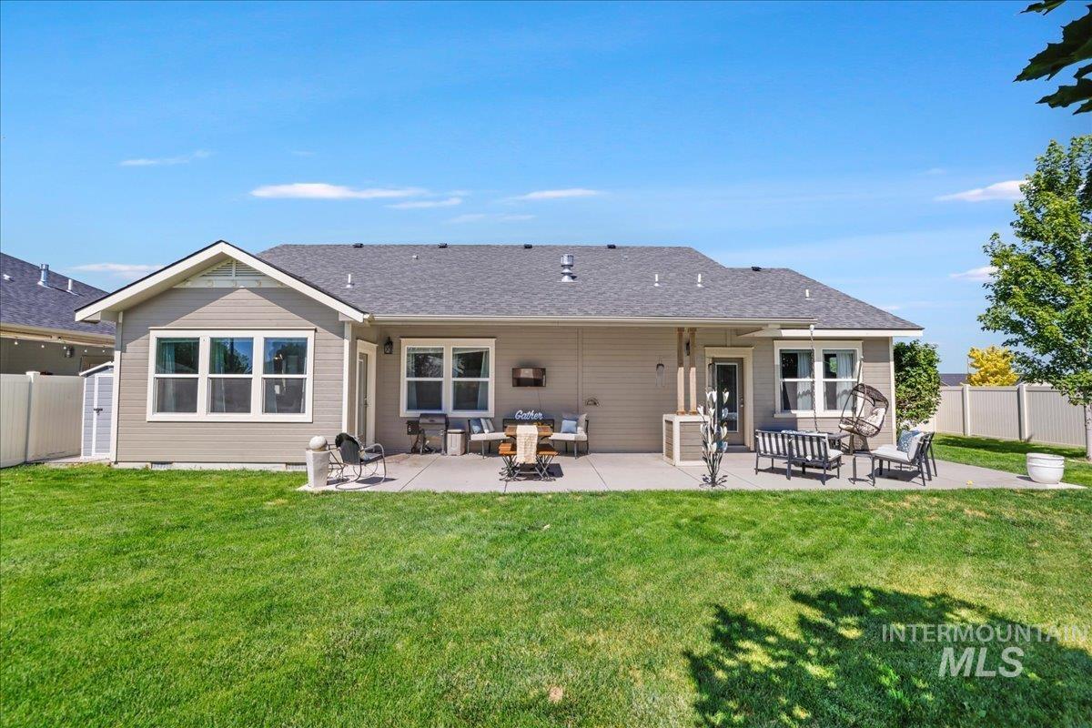 Rear view of property with an outdoor hangout area, a fenced backyard, a patio, and a shingled roof