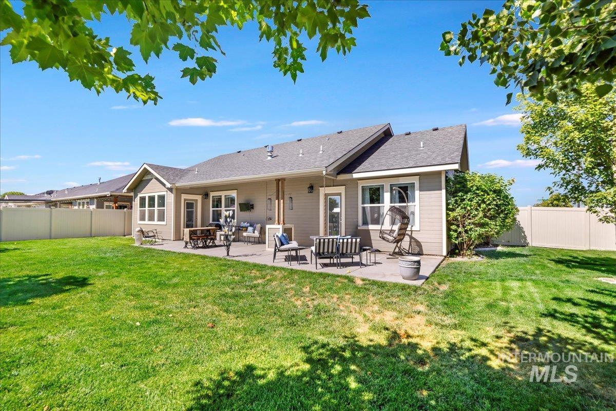 Back of property with a patio area, a fenced backyard, and a shingled roof