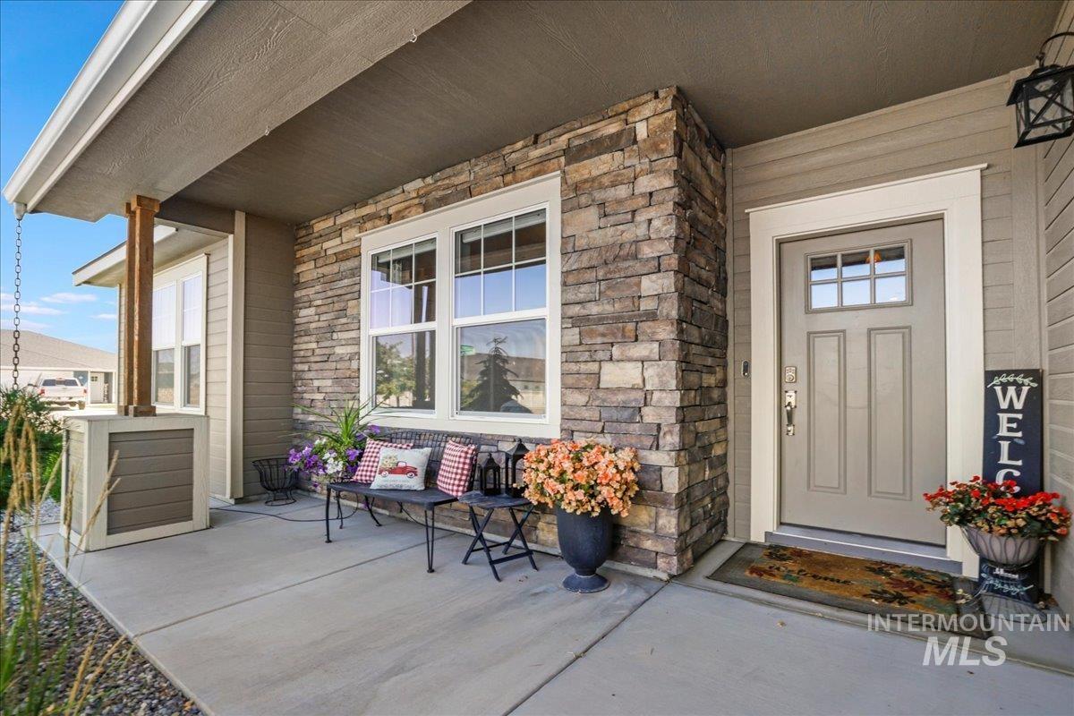 Entrance to property with a porch and stone siding