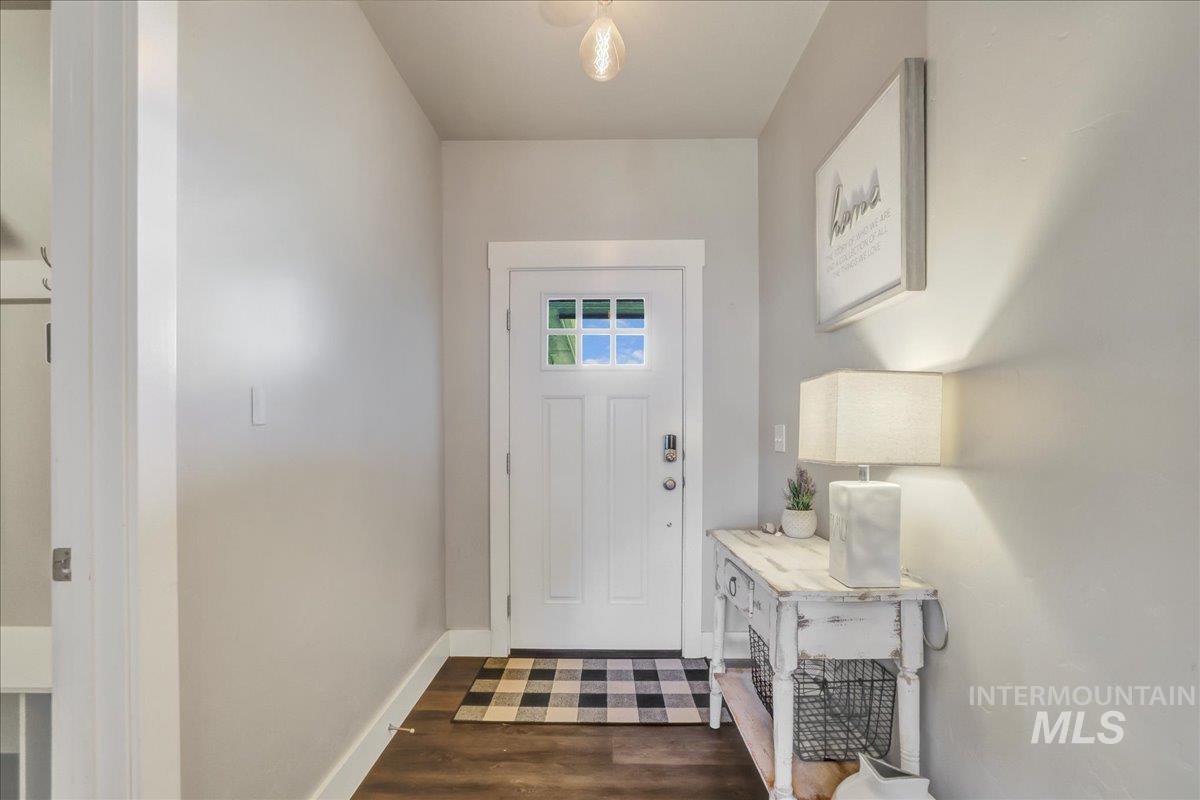 Entrance foyer with dark wood-type flooring and baseboards