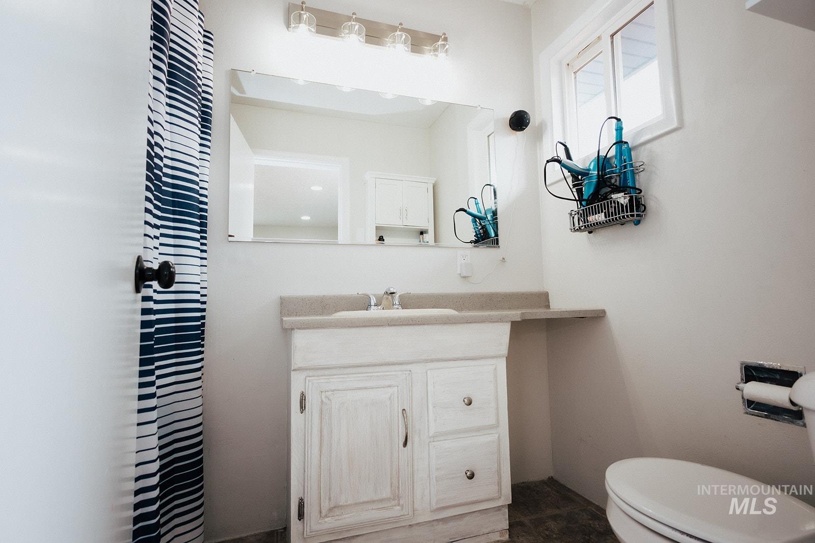 Half bathroom featuring vanity and toilet