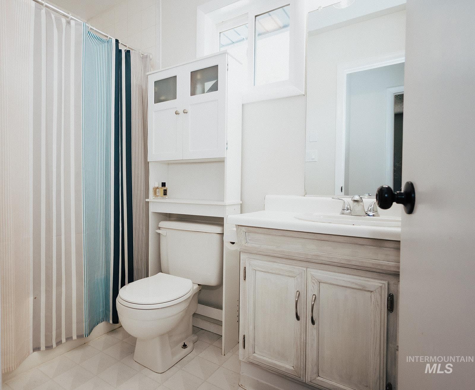 Full bathroom with vanity and a shower with shower curtain