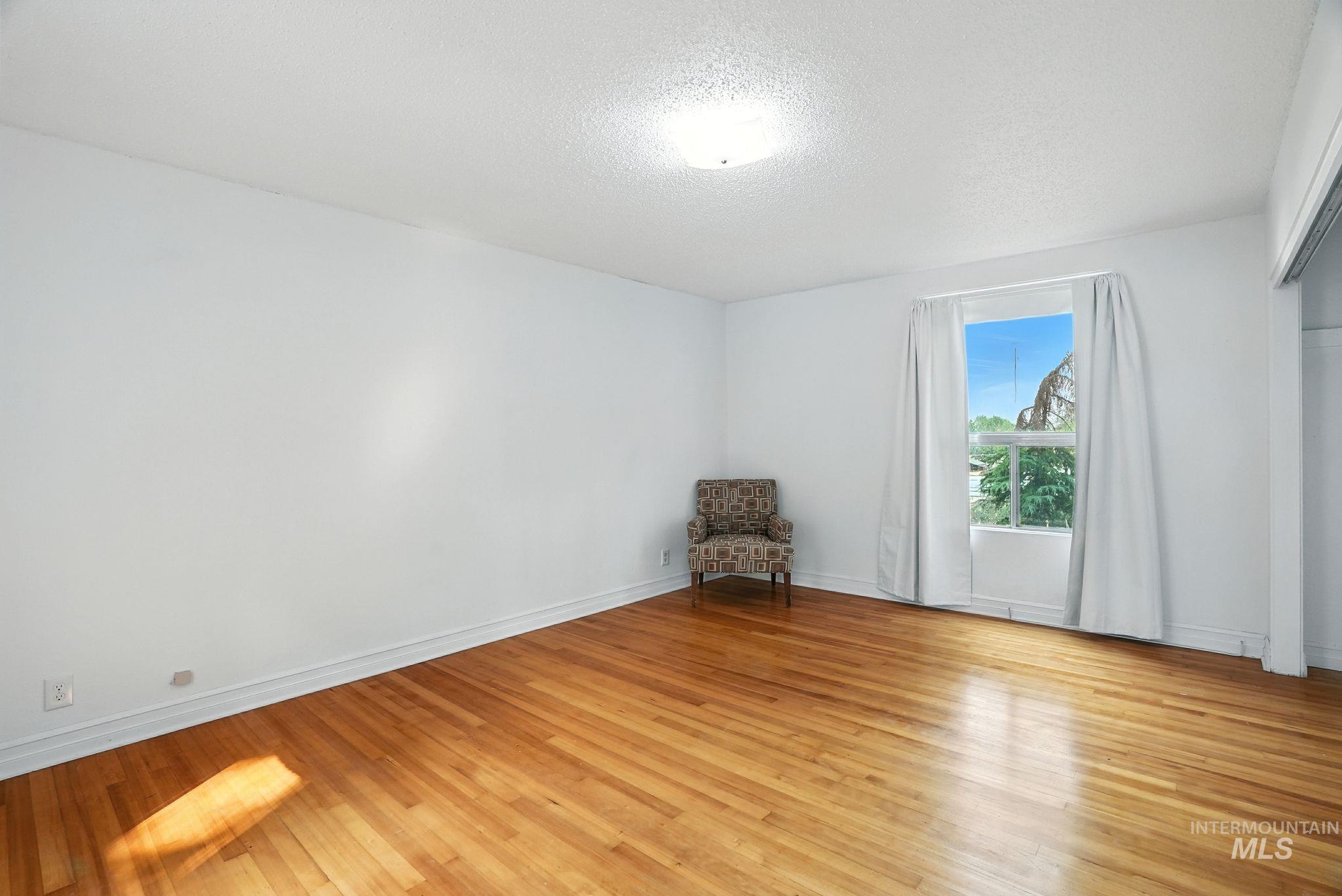 Spare room with light wood-type flooring and a textured ceiling