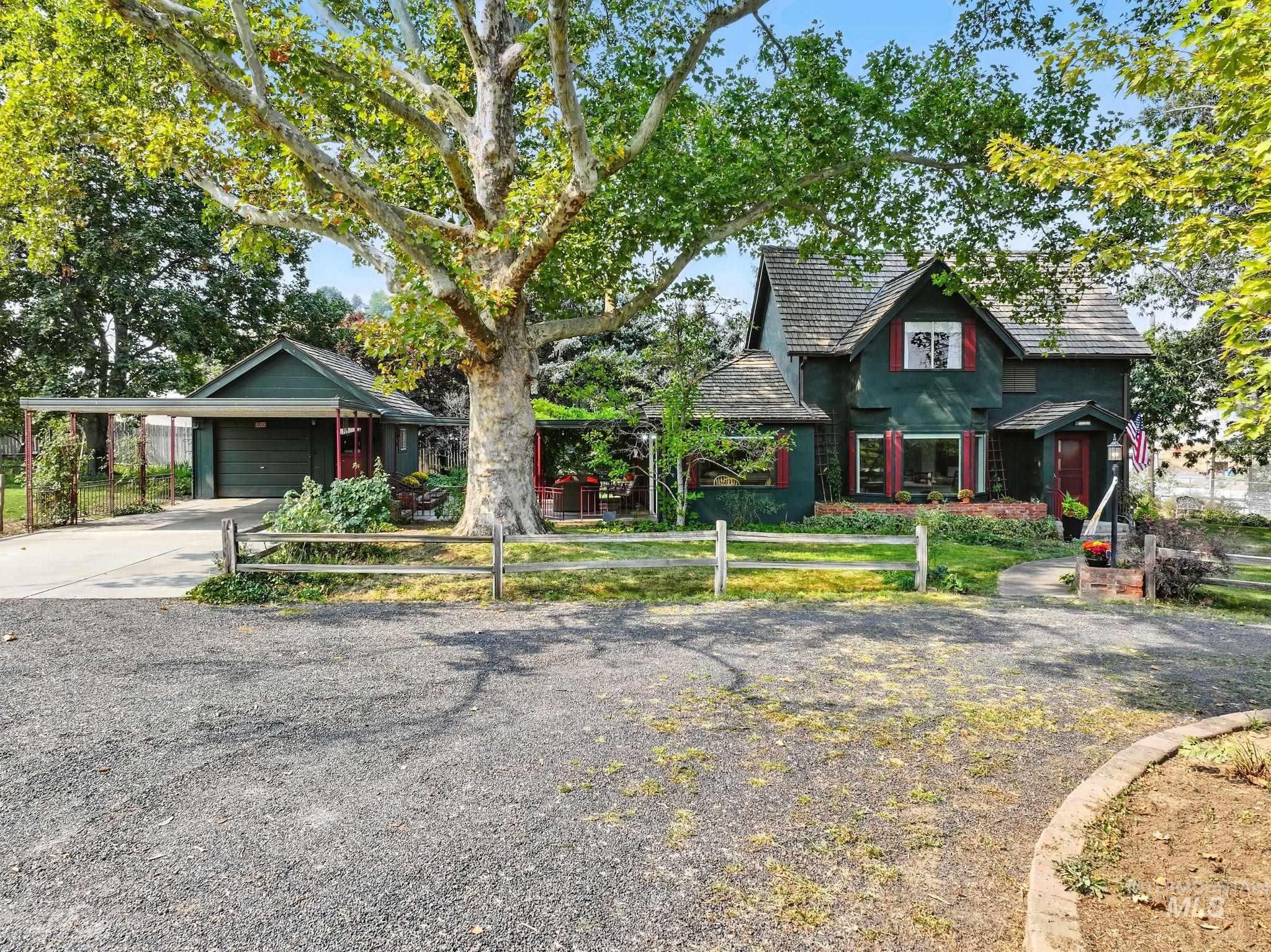 View of front of property featuring concrete driveway, a carport, and an attached garage